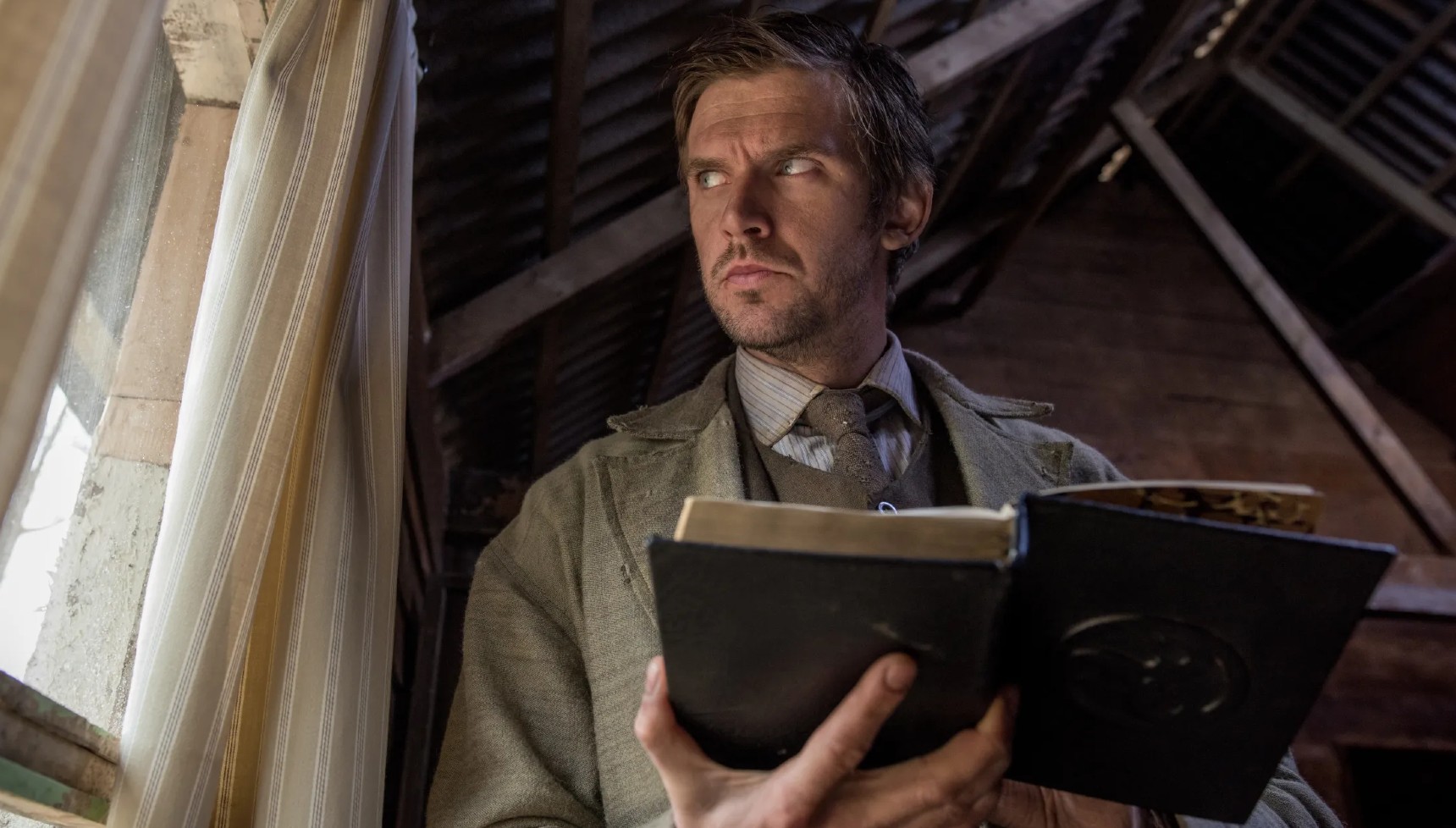 Dan Stevens holding a book in Apostle