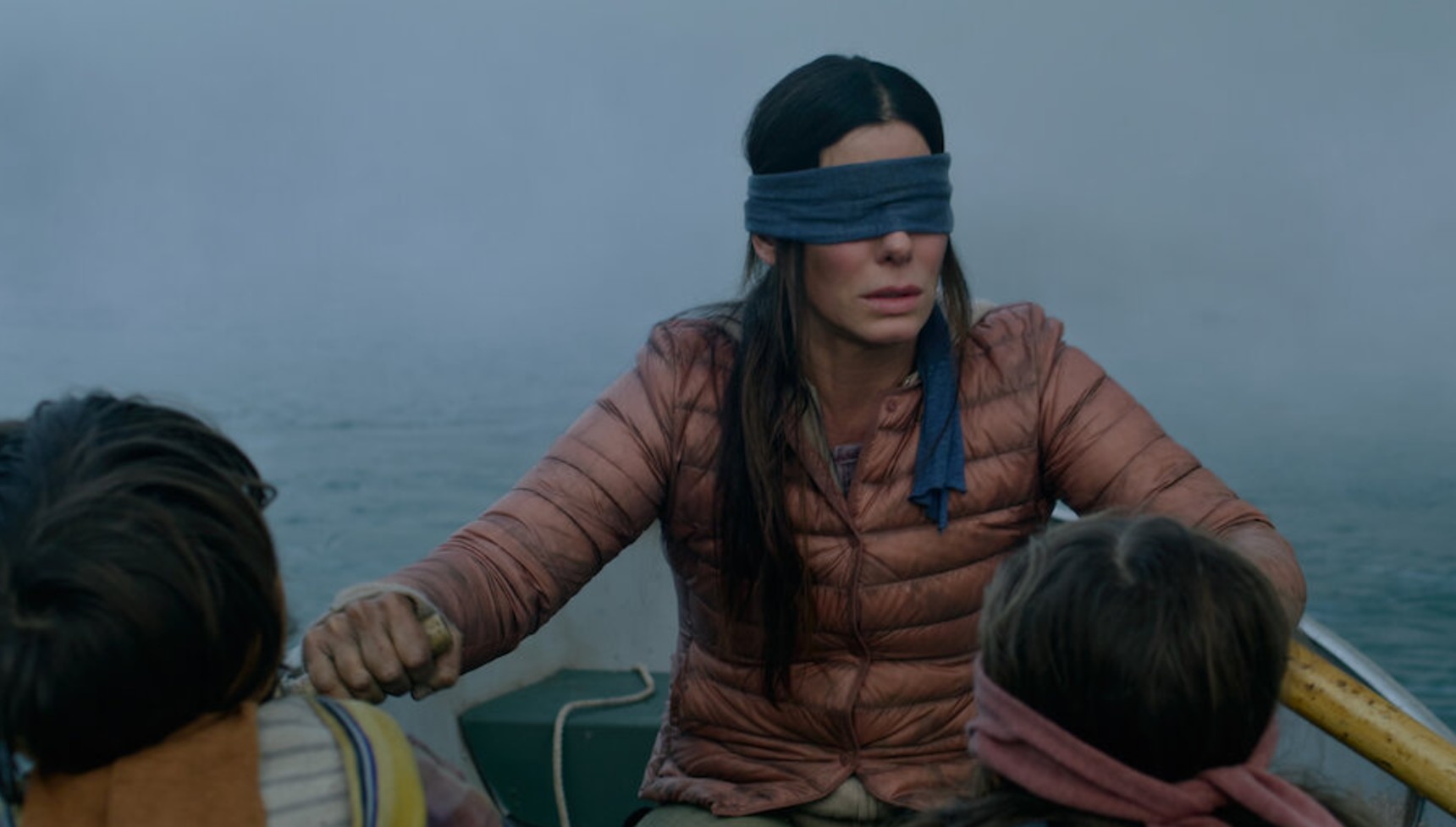 Sandra Bullock with a blindfold on as she rows a boat in Bird Box
