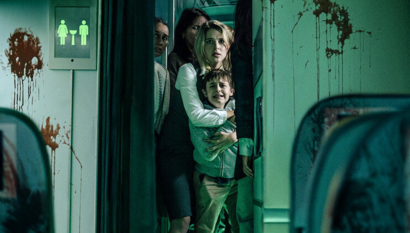 Passangers on a plane hiding down the aisle with blood-splattered walls in Blood Red Sky