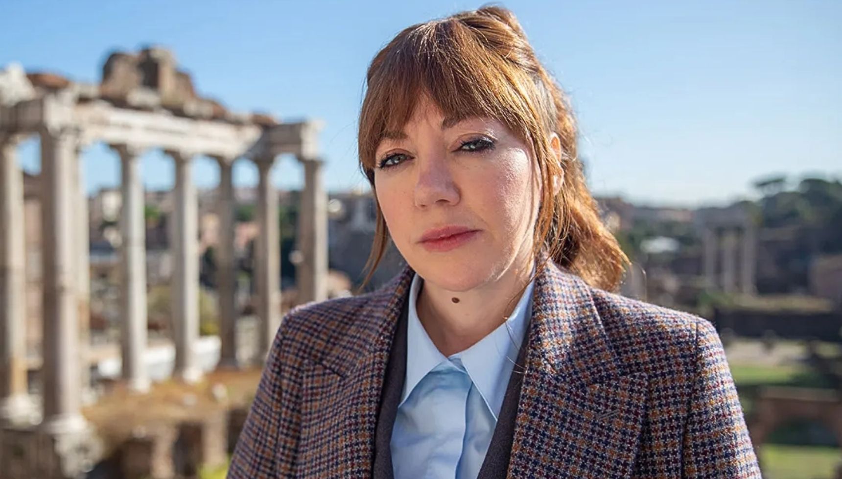 Philomena Cunk standing in front of ancient ruins