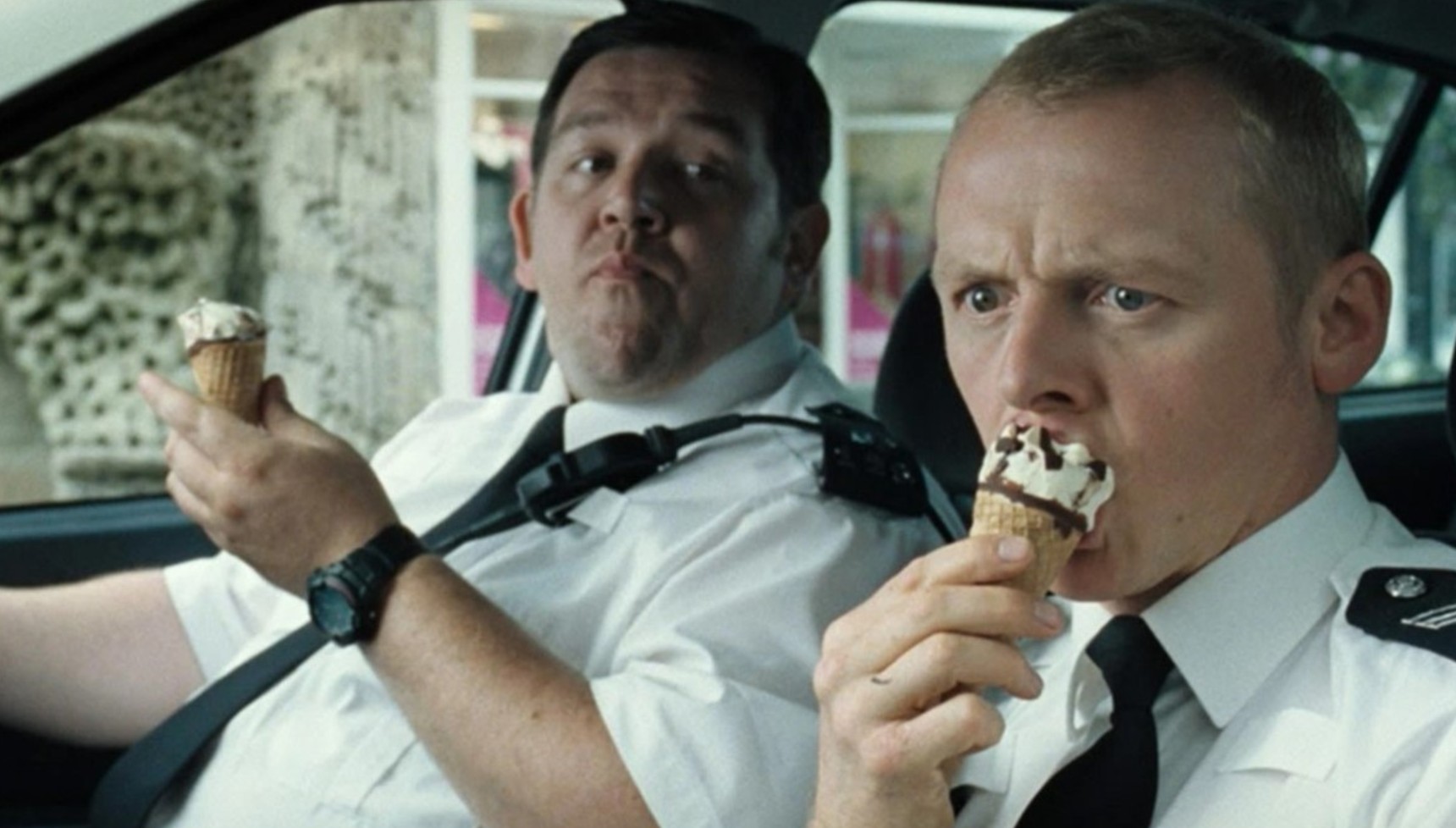 Simon Pegg eating a cornetto with Nick Frost in police uniform in Hot Fuzz