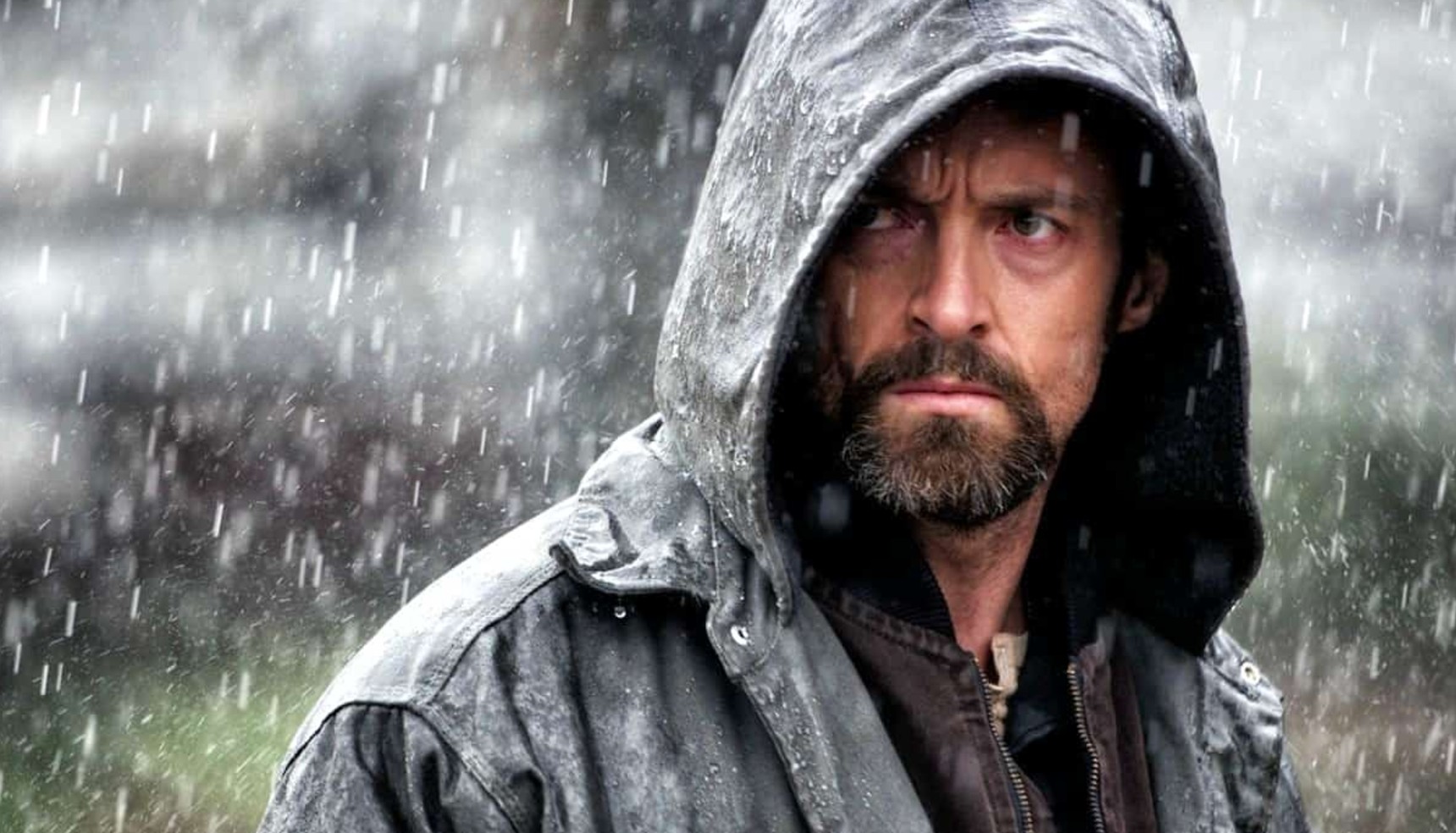 Hugh Jackman in a hooded jacket in the rain in Prisoners