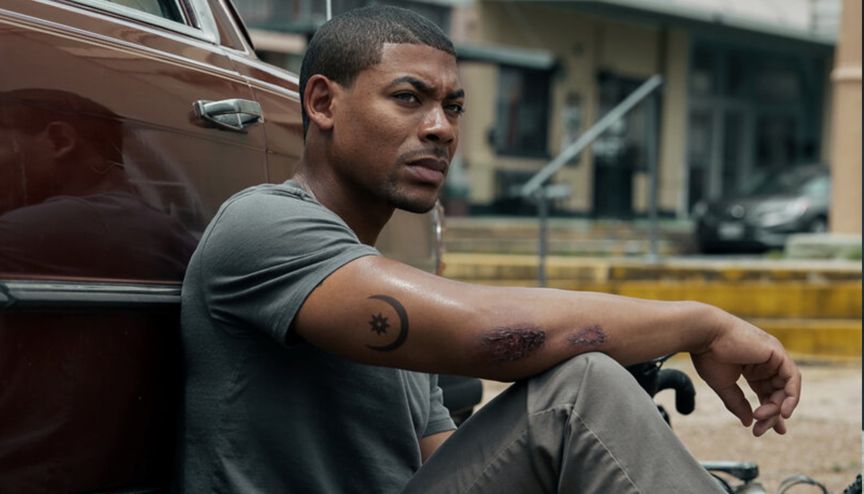 Aaron Pierre sitting against a truck in Rebel Ridge