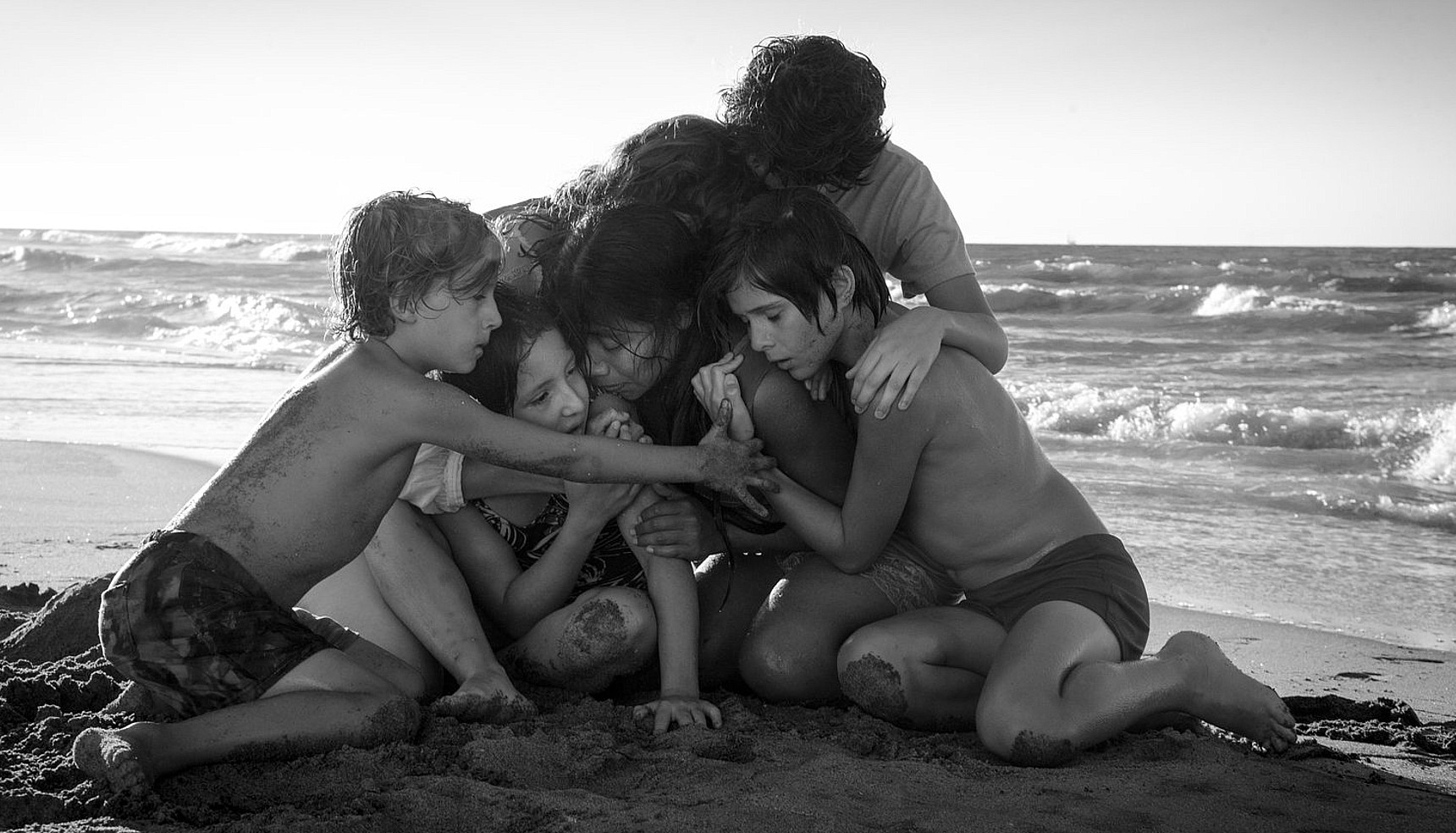 A family huddling on the beach in Roma