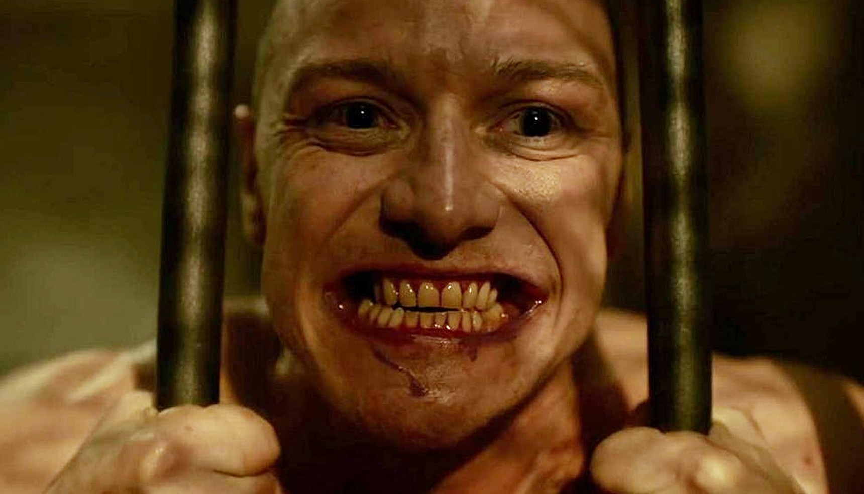 James McAvoy grinning as he pulls bars apart in Split