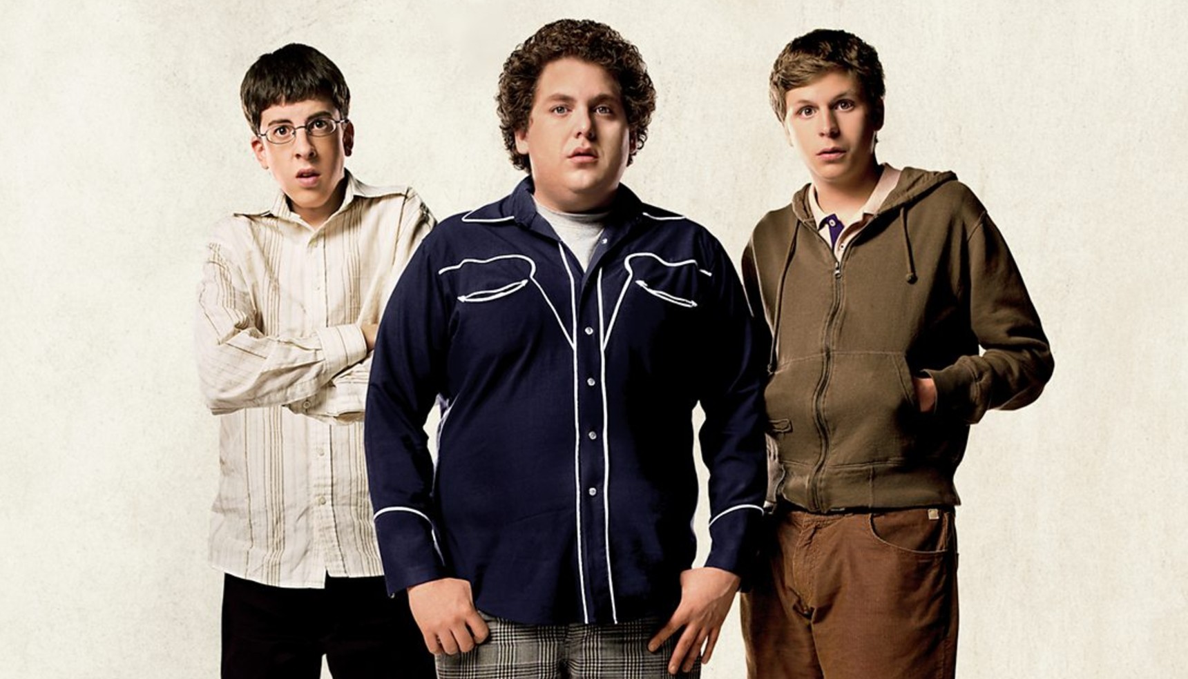Christopher Mintz-Plasse, Jonah Hill, and Michael Cera posing together in character on the Superbad poster