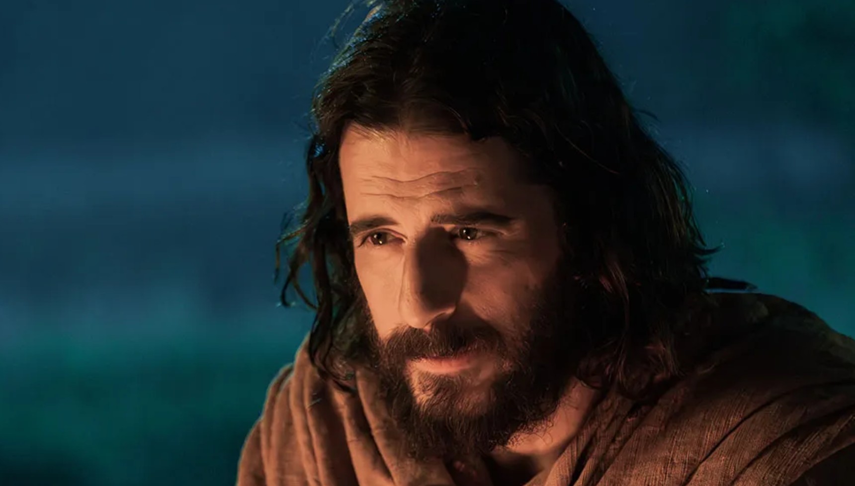 Jonathan Roumie's Jesus with the glow of a fire on his face in The Chosen