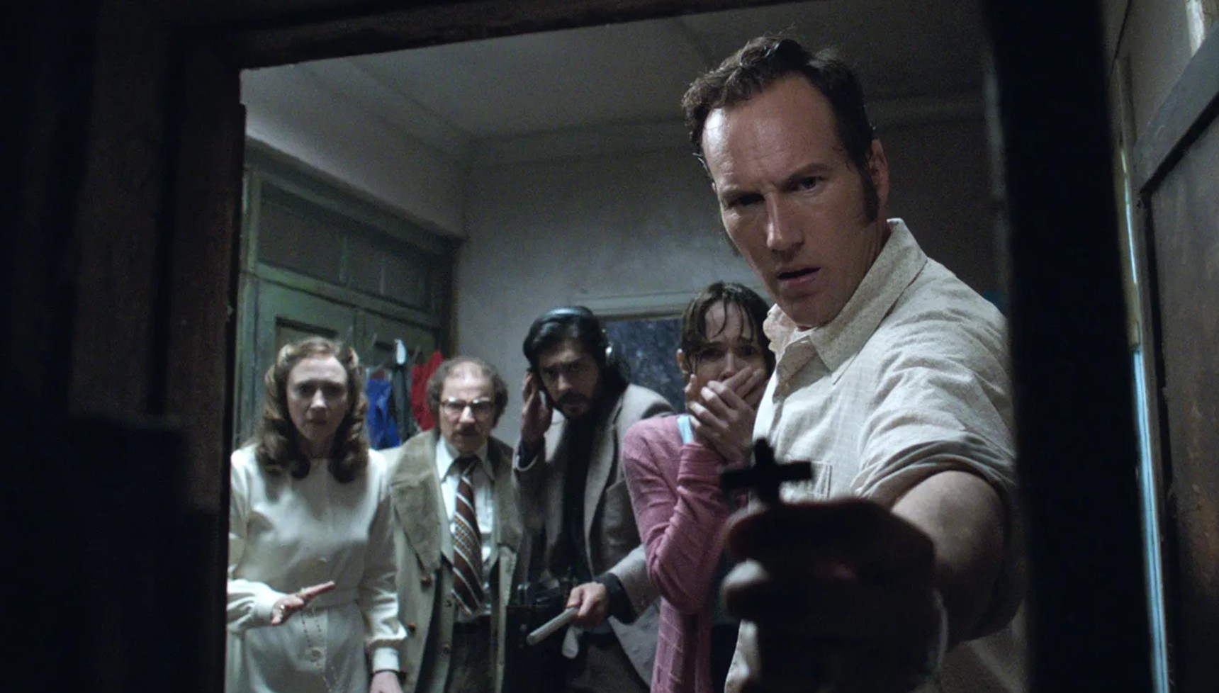 Patrick Wilson holding a camera next to the cast of The Conjuring 2