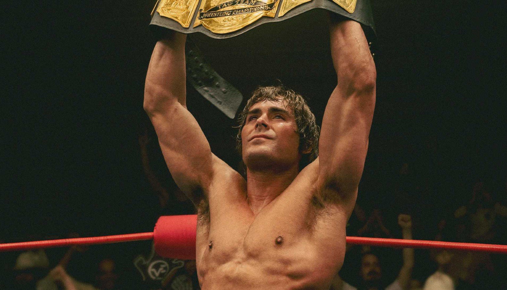 Zack Efron shirtless and holding a wrestling belt in The Iron Claw [Credit: A24]