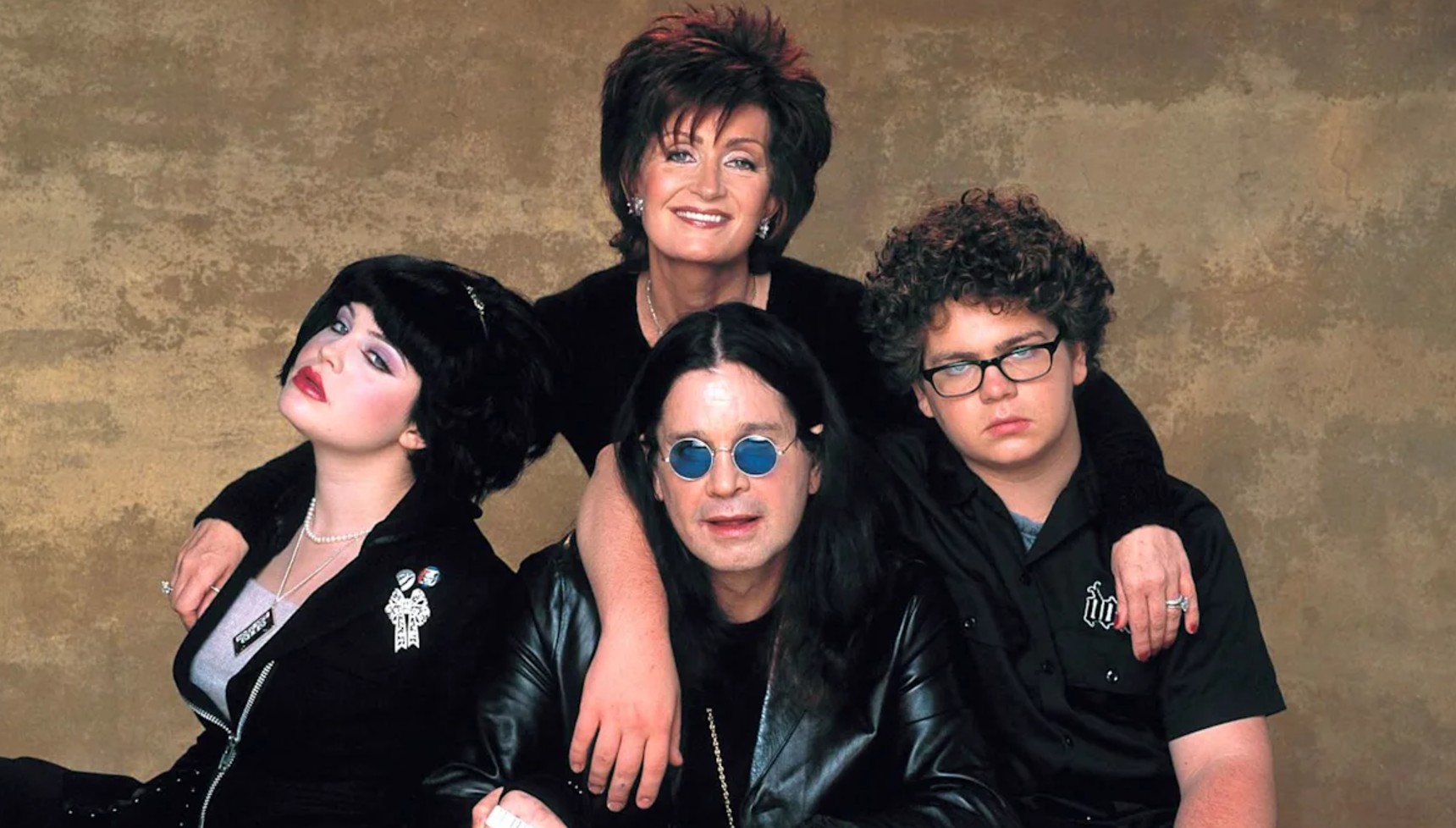 Sharon Osbourne with her arms around the rest of the Osbourne family 
