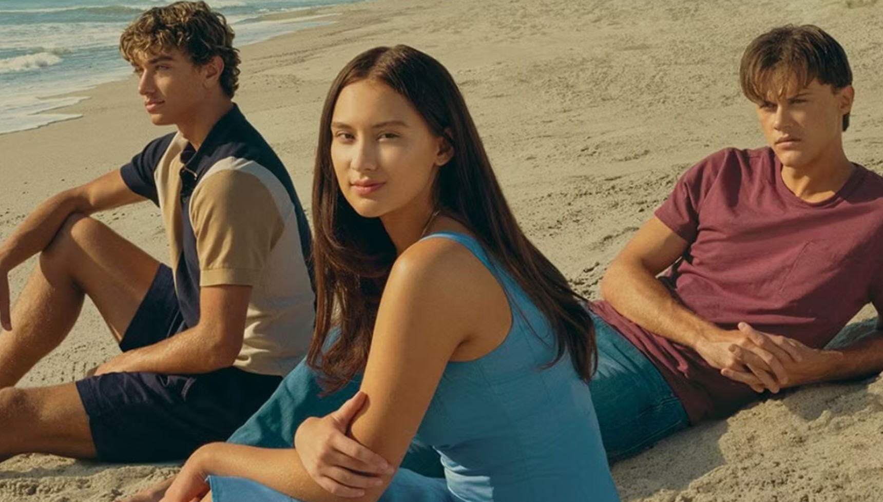 Conrad, Belly, and Jeremiah lying on the beach in The Summer I Turned Pretty