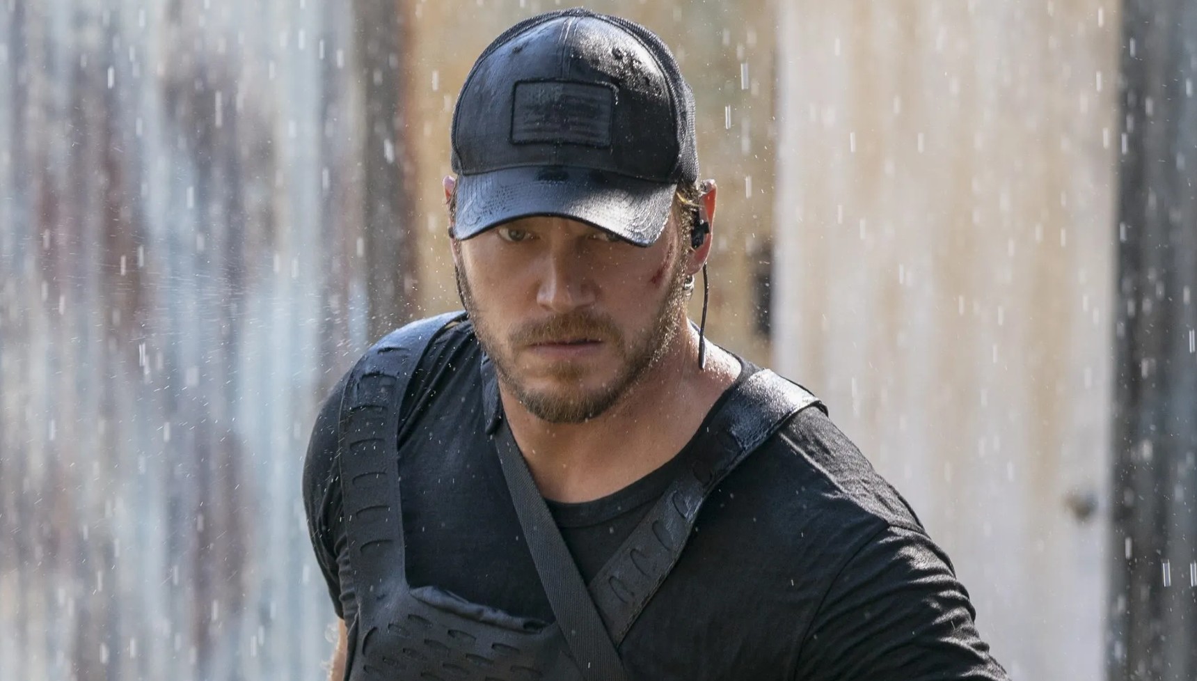 Chris Pratt wearing a hat and a military vest in the rain in The Terminal List