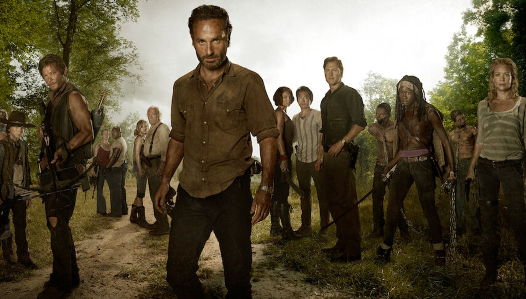 Andrew Lincoln's Rick Grimes standing in front of the cast of The Walking Dead