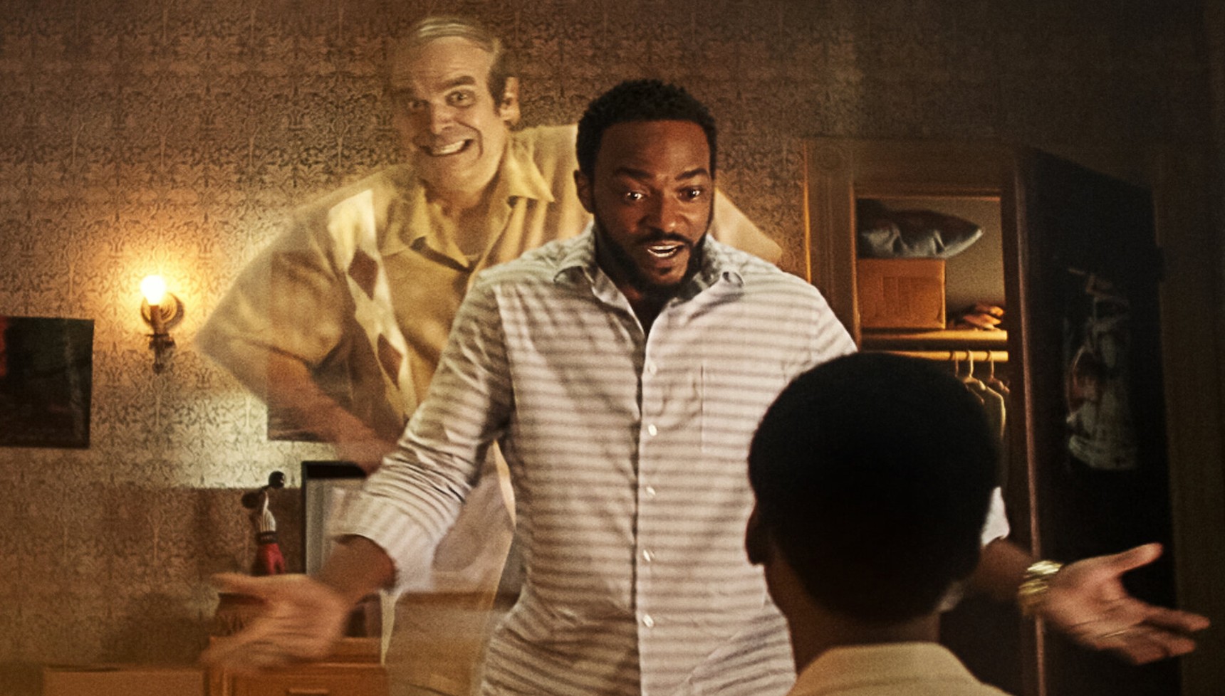 David Harbour as a ghost behind Anthony Mackie as he talks to a child in We Have a Ghost