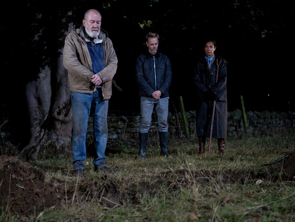Bear stands over Anya's grave as Celia and Ray look on
