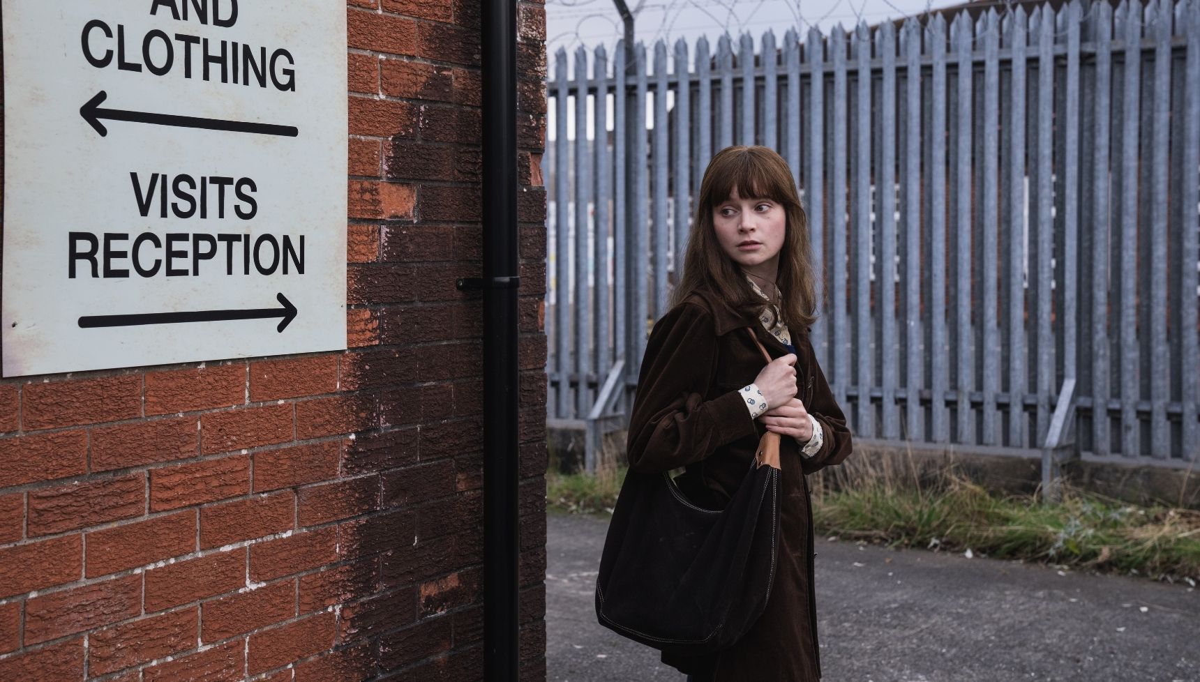 Lola Petticrew as Cushla Lavery standing outside a prison