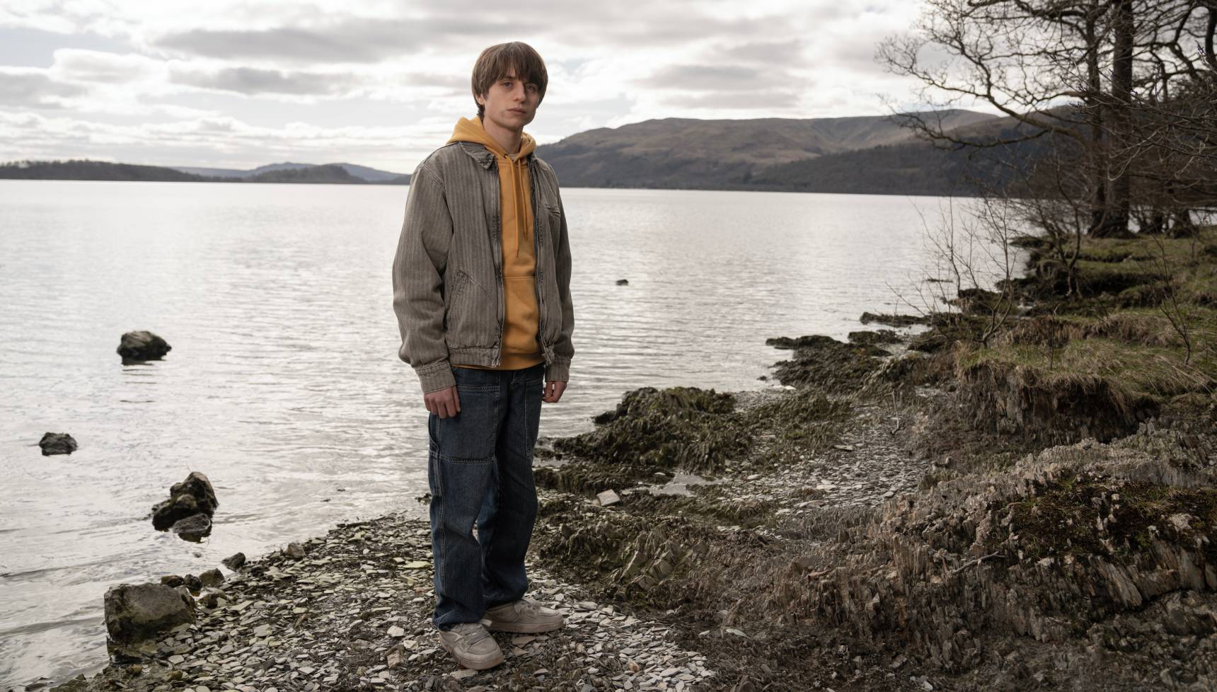 Summerwater's Alex (Callum Ross) standing with a beautiful loch behind him