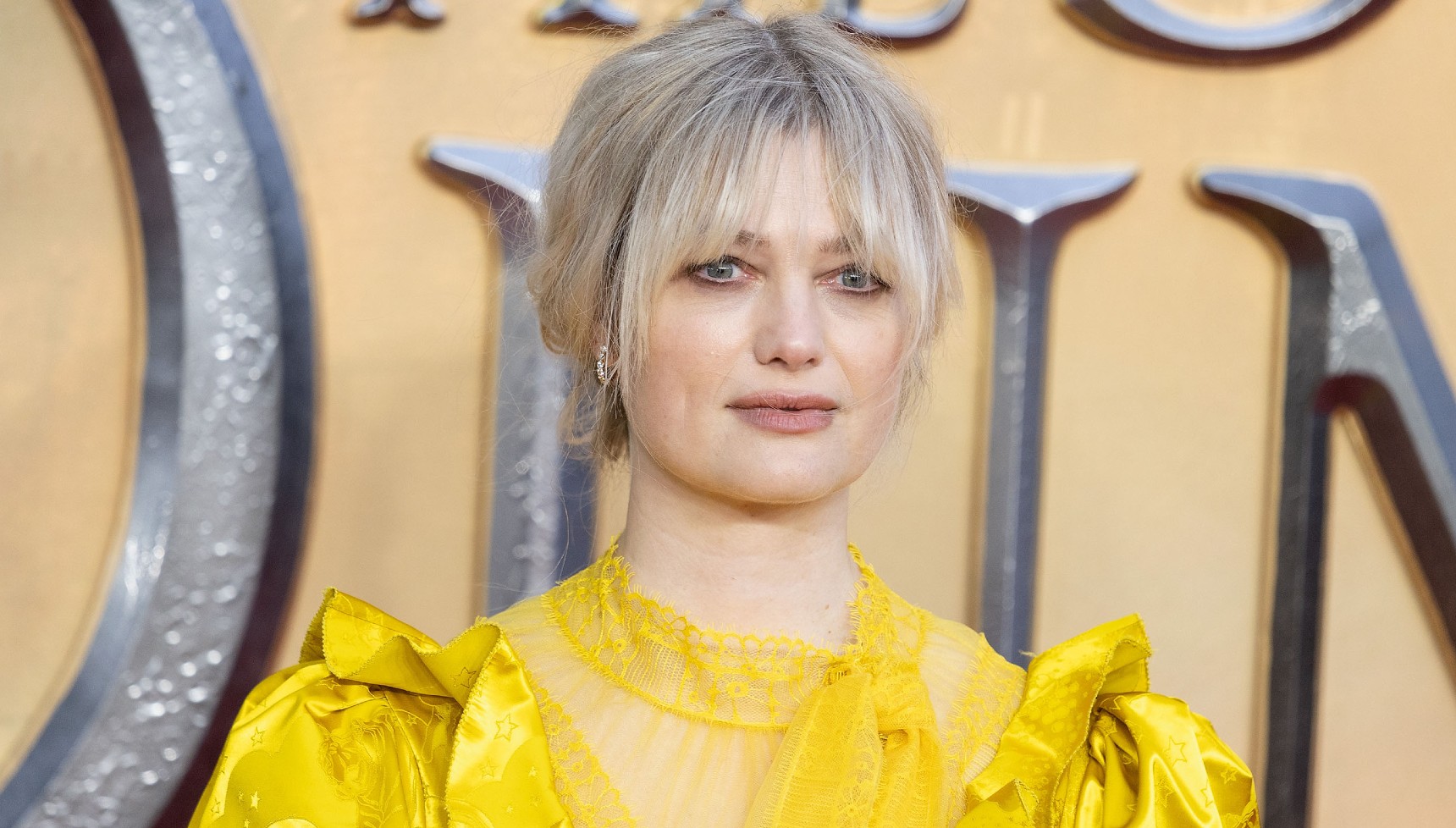 Alison Sudol in a yellow dress on the red carpet for Fantastic Beasts: The Secrets of Dumbledore