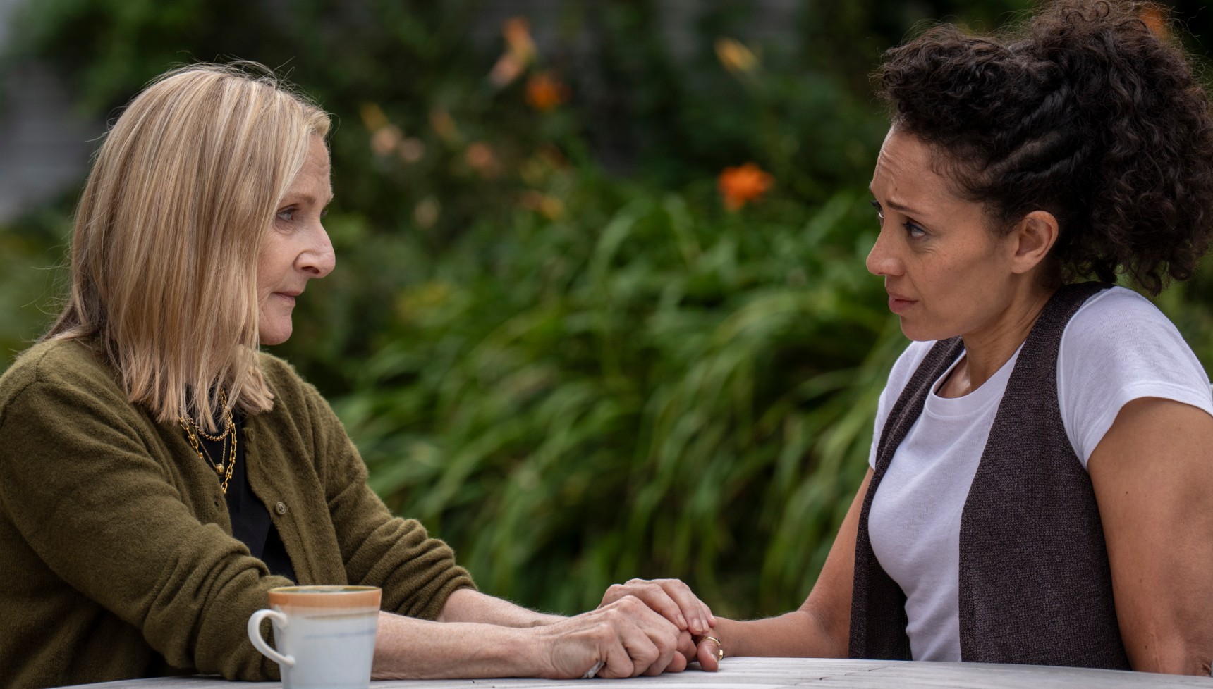 Lesley Sharp and Camilla Beeput's Bergerac characters holding hands at a table