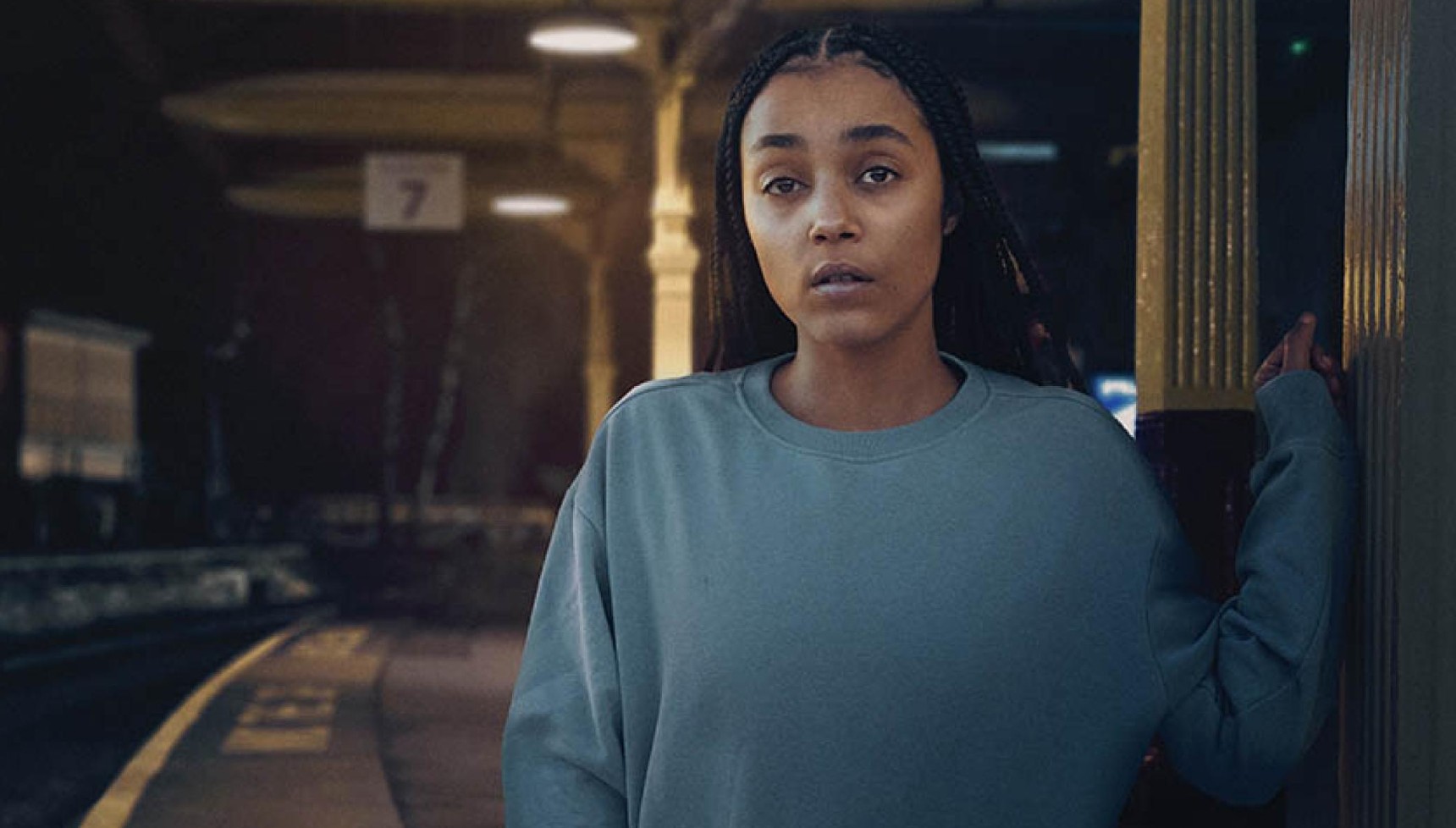 Jasmine Jobson stands with her hand against a train station wall in Platform 7