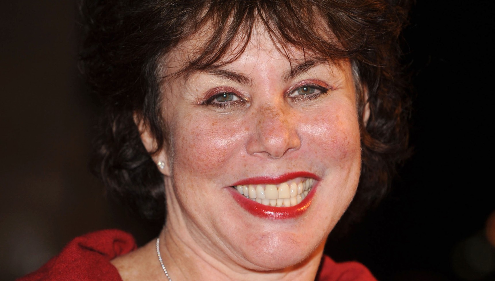 Ruby Wax smiling with red lipstick on