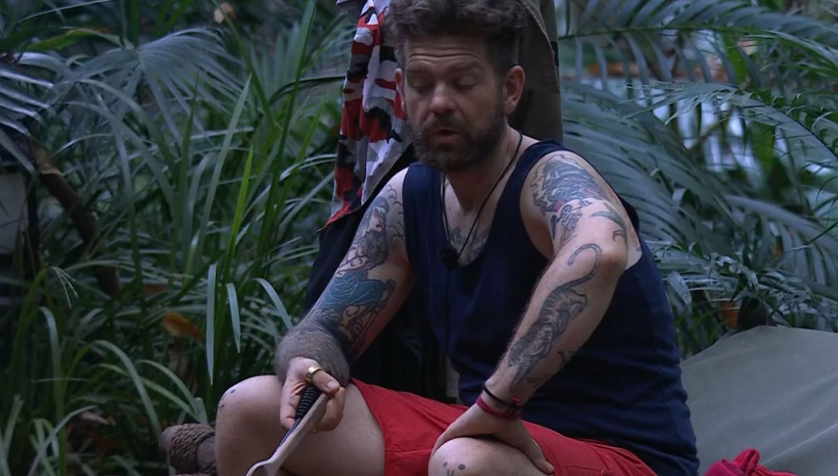 Jack Osbourne sitting round fire on I'm A Celebrity