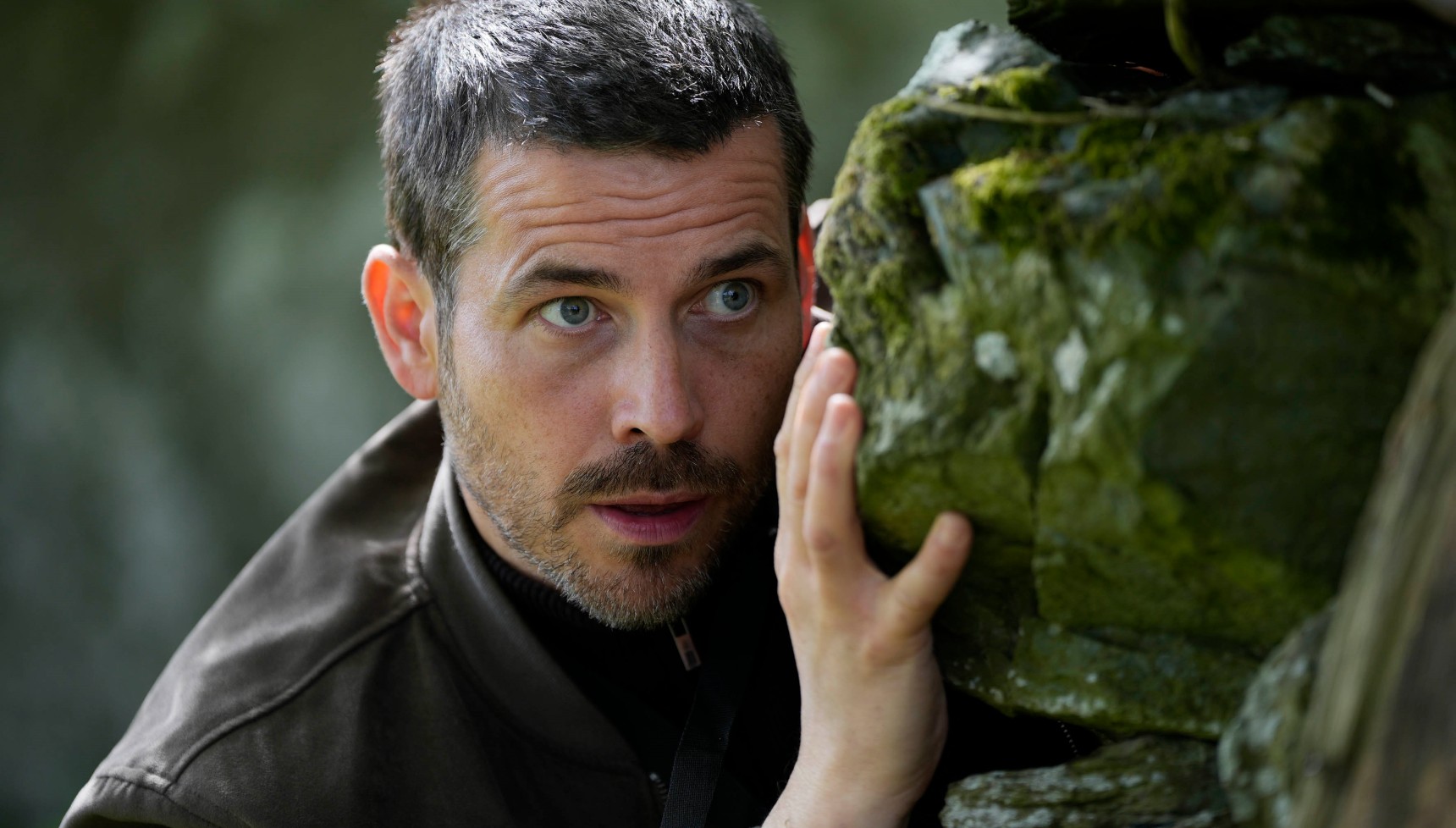 Rob James-Collier hides behind rock as Ben Cooper in Cooper & Fry