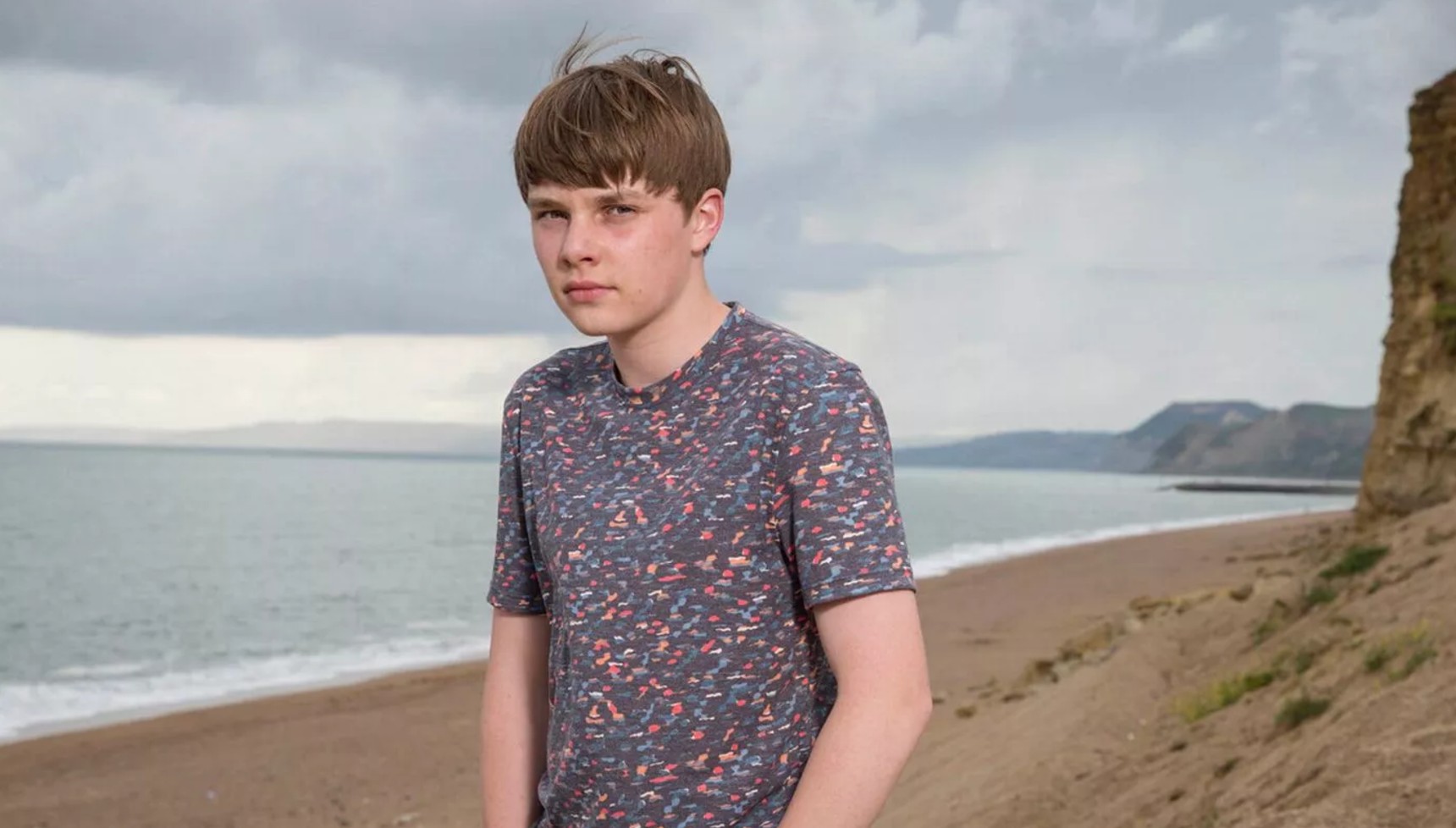 Adam Wilson standing on a beach in Broadchurch