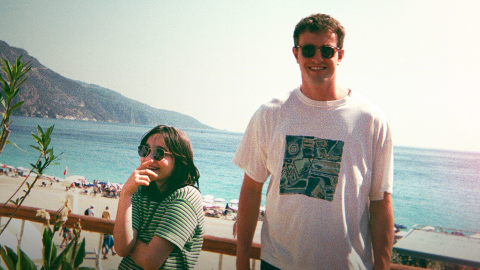 Frankie Corio and Paul Mescal wearing sunglasses near a beach in Aftersun