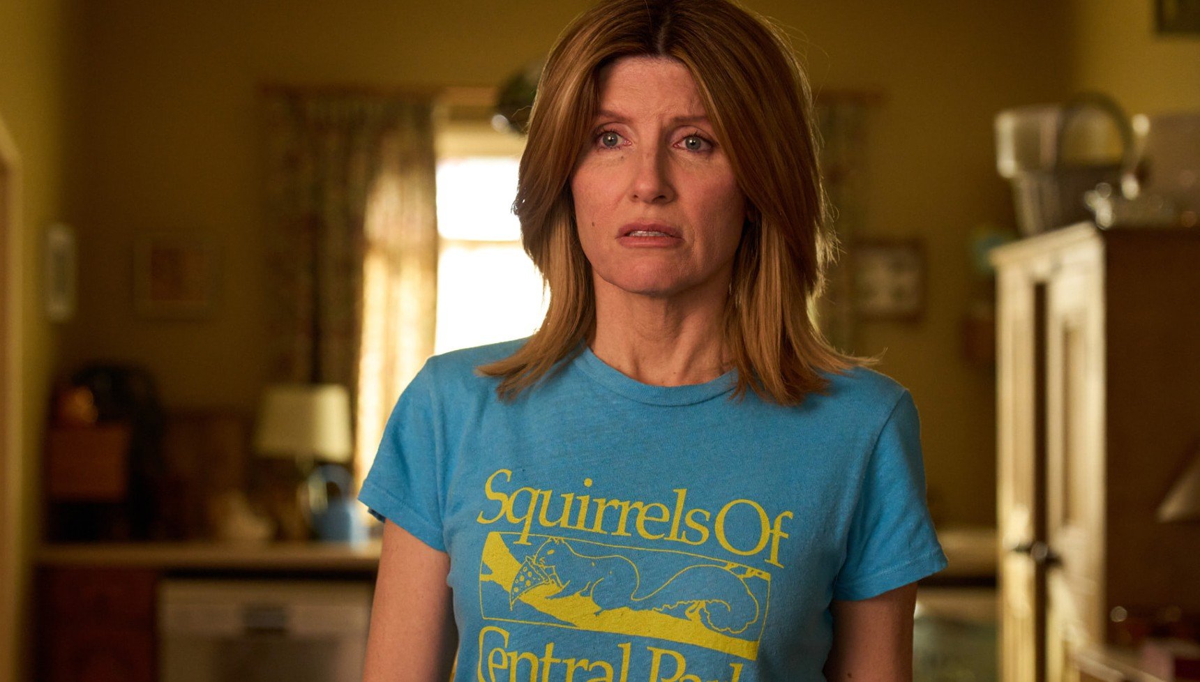 Confused-looking woman in a blue and yellow T-shirt