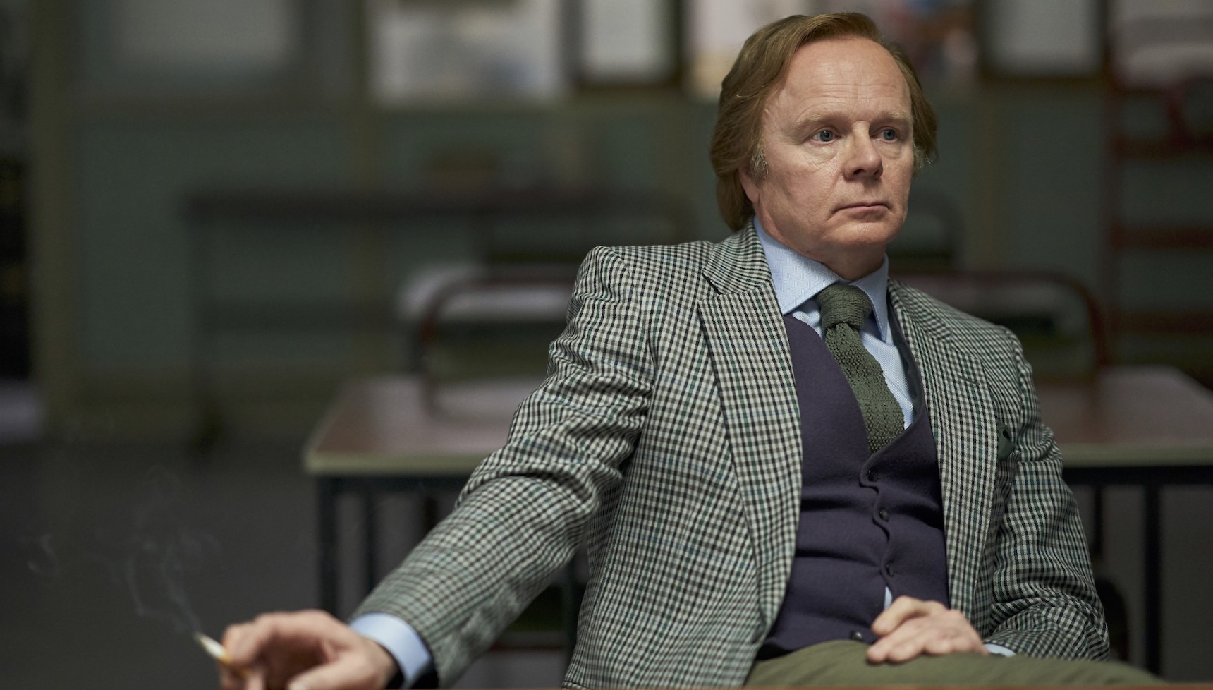 Jason Watkins holding a cigarette in costume as Brian Masters in Des