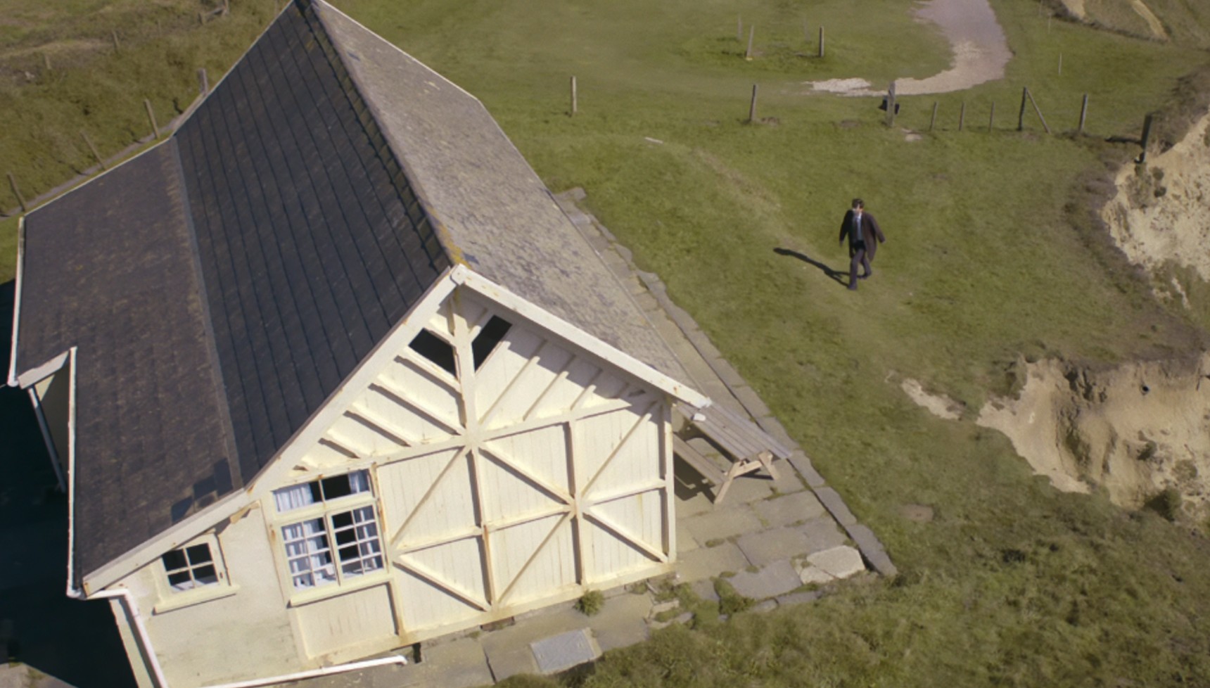 David Tennant walking towards a white chalet in Broadchurch 
