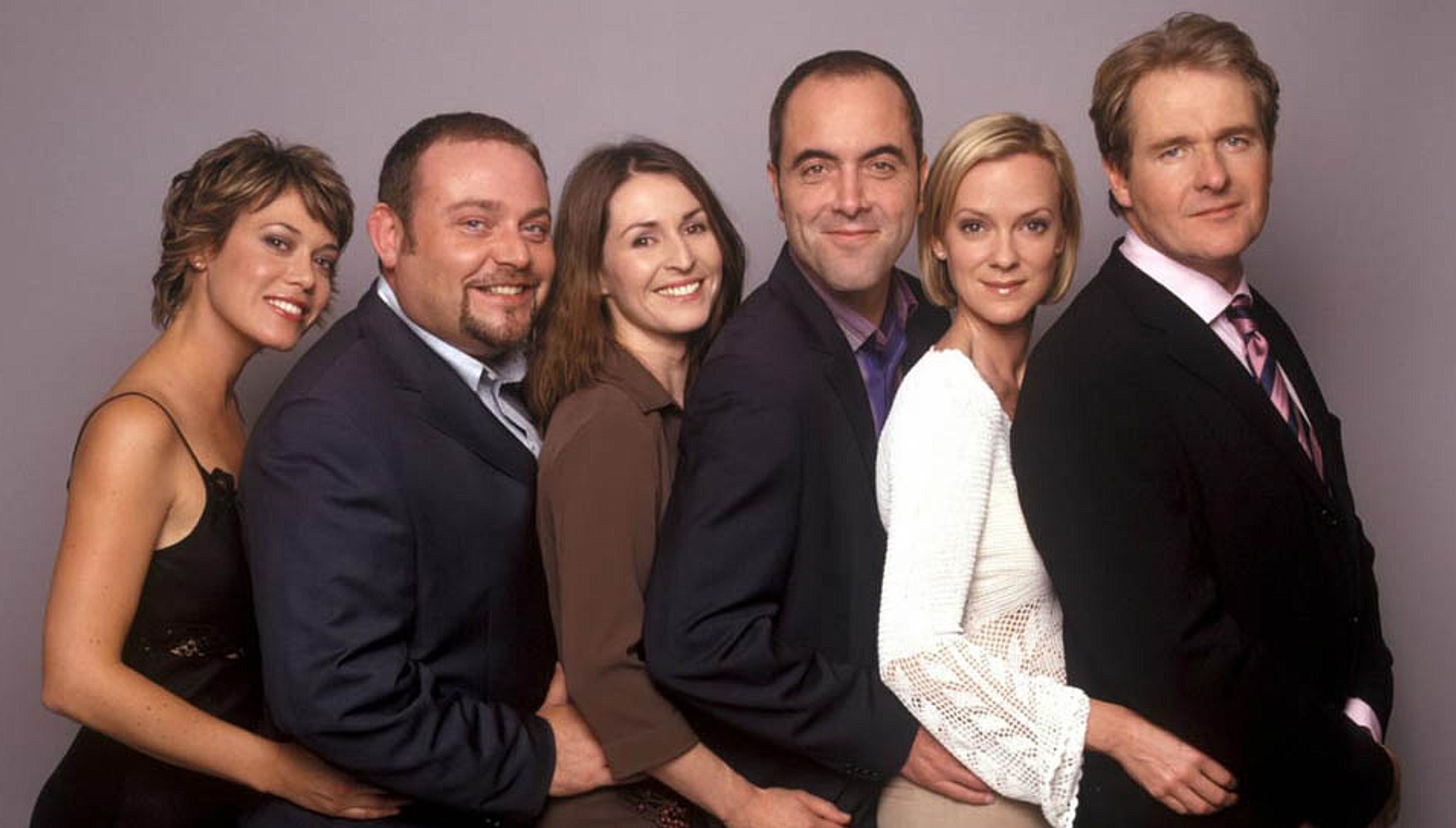 The cast of Cold Feet hugging each other from behind