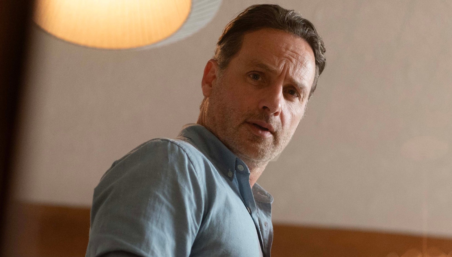 Andrew Lincoln in a blue shirt looking down in Coldwater