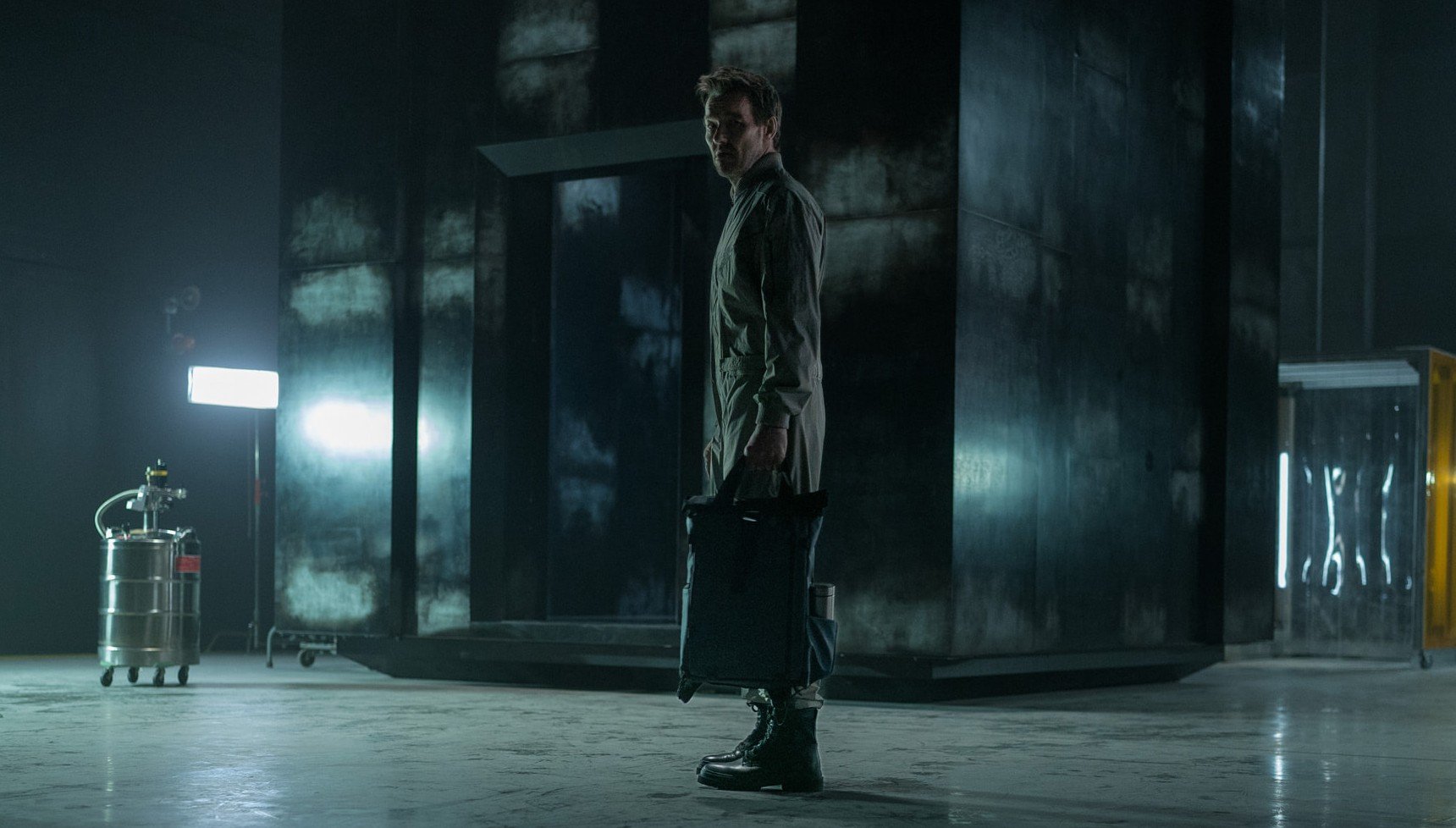 A man holding a bag in a dark facility