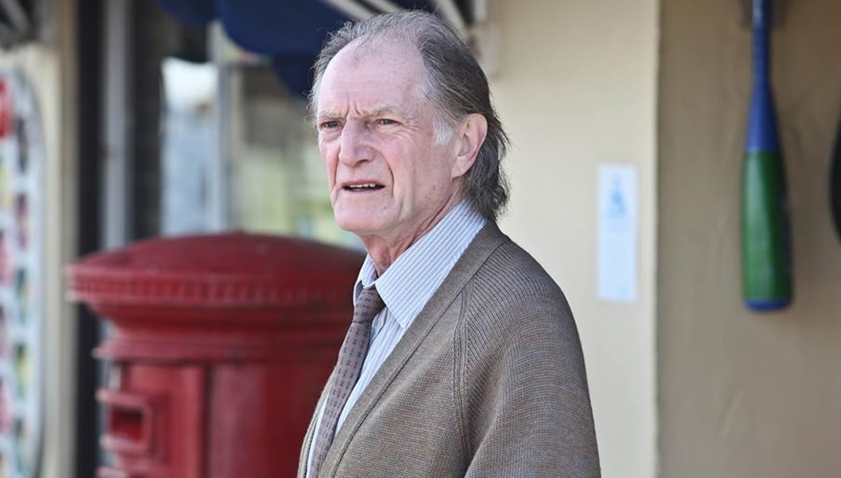 David Bradley standing near a post box in Broadchurch
