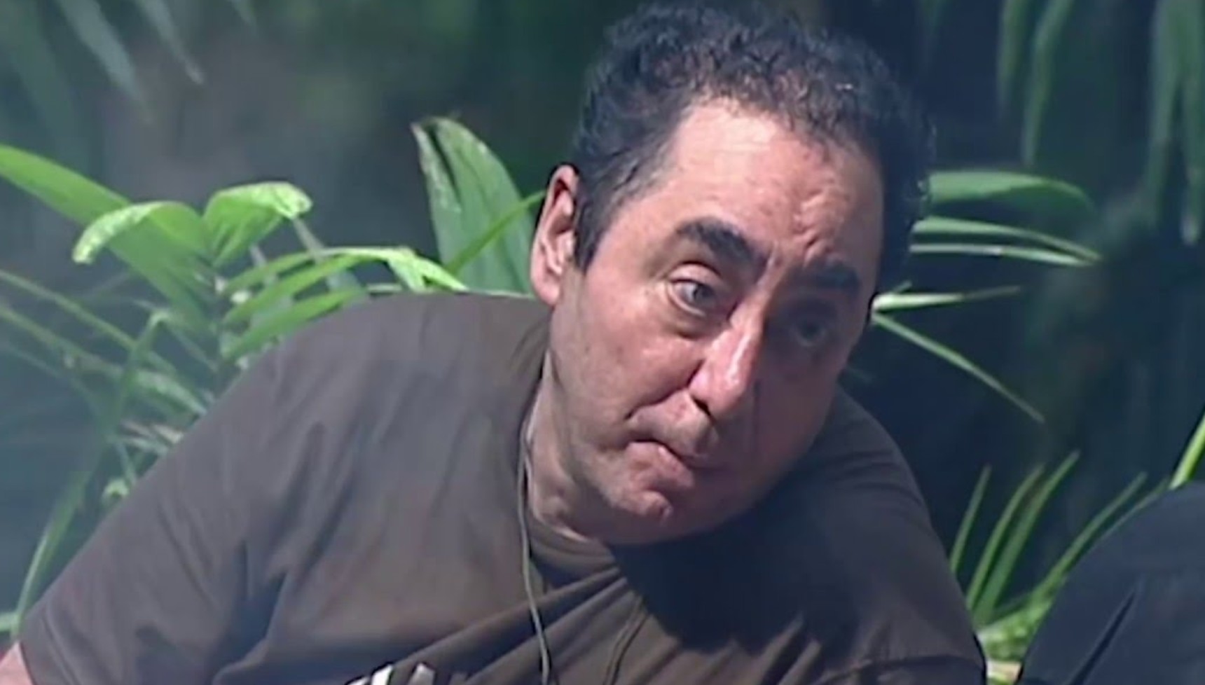 David Gest in a brown t-shirt in the jungle
