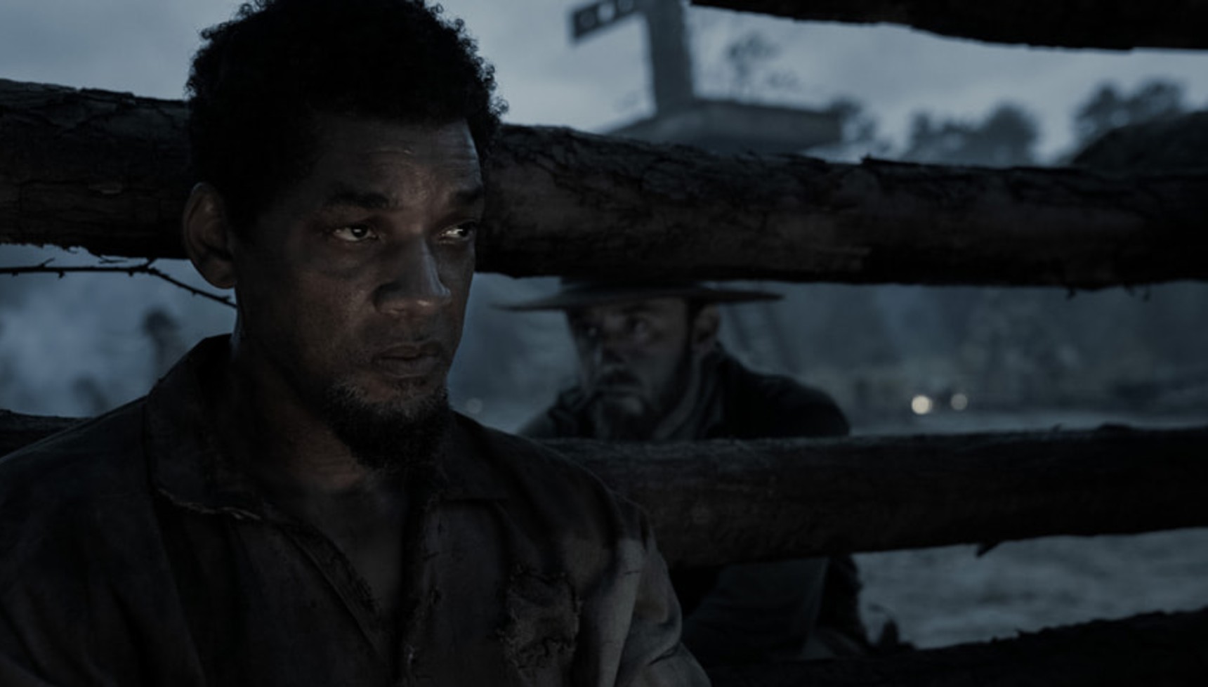 A Black slave is peered at by his captor