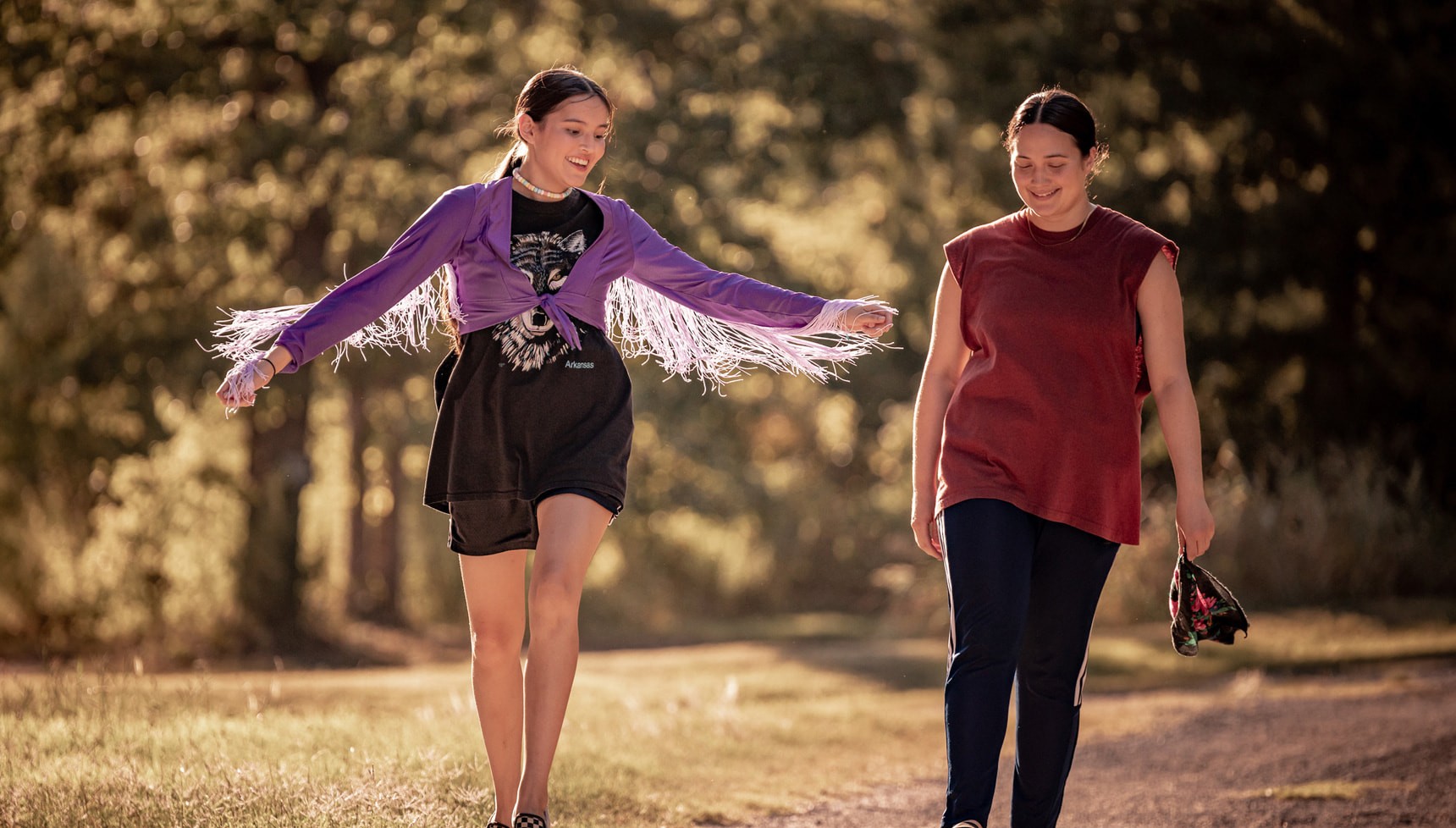 Two women walking together in the sun