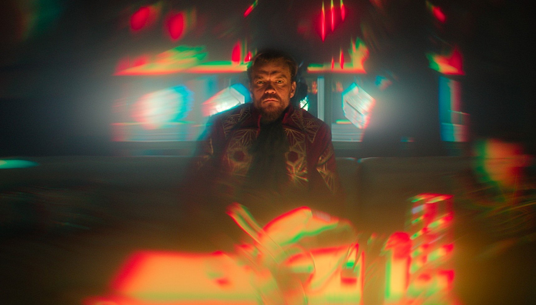 Man surrounded by fuzzy lighting in a dark room