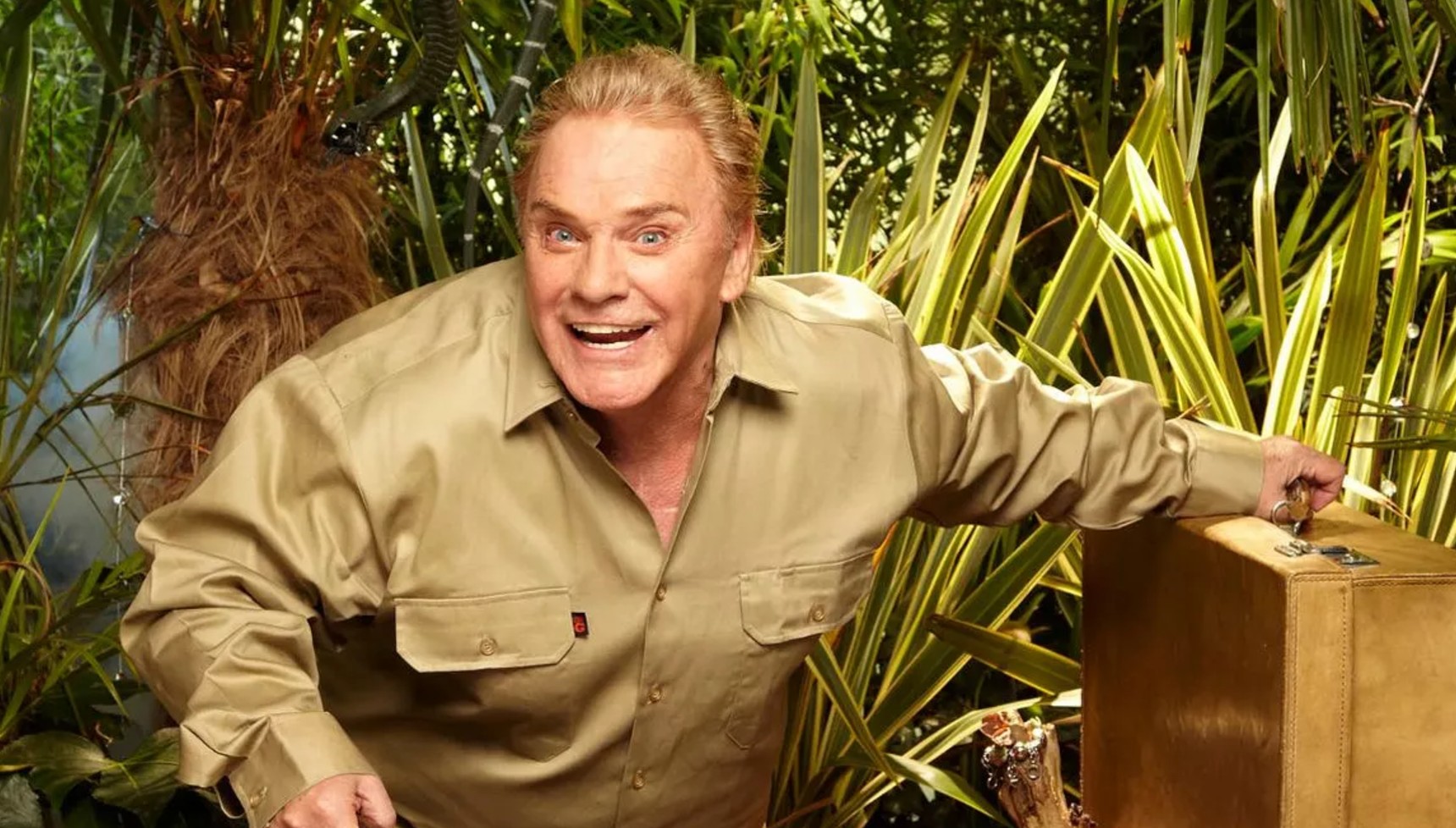 Freddie Starr in a khaki shirt ducking in the jungle in I'm A Celebrity