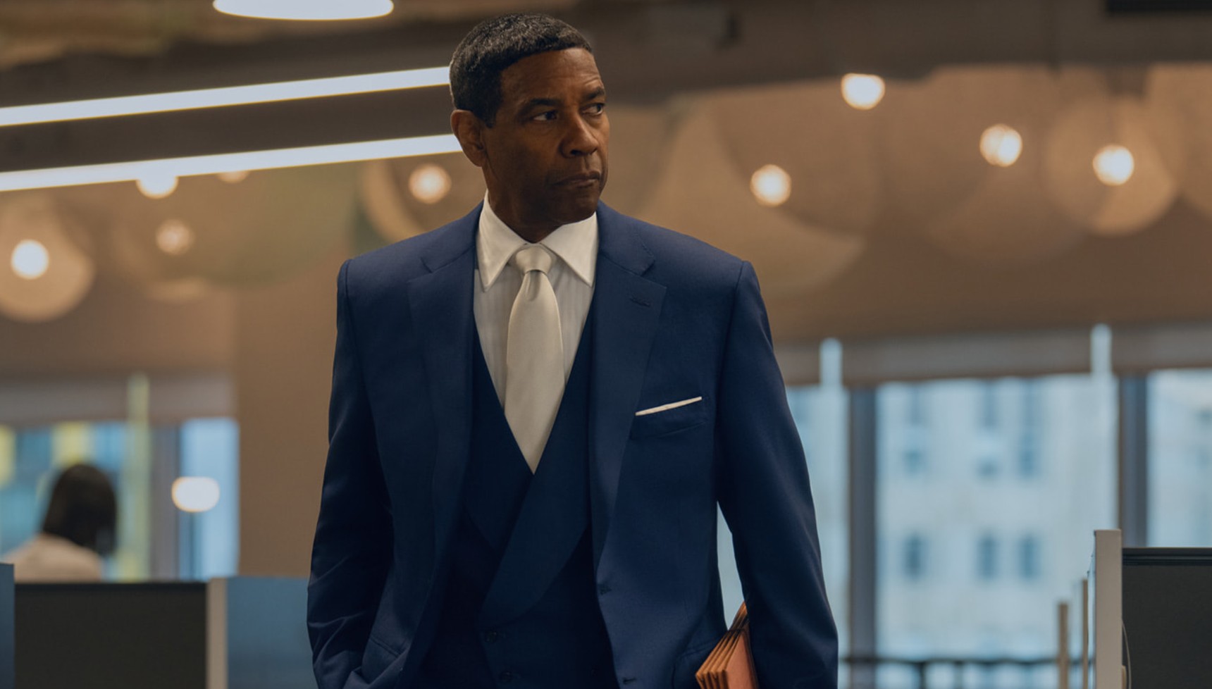 A suited businessman holding paper documents