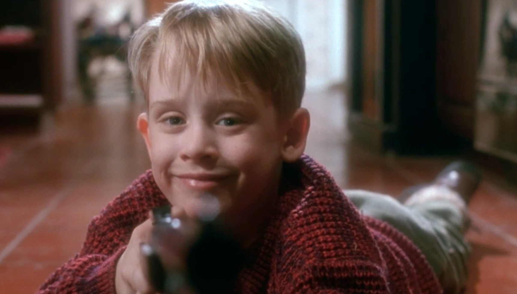 Macaulay Culkin holding a gun in Home Alone