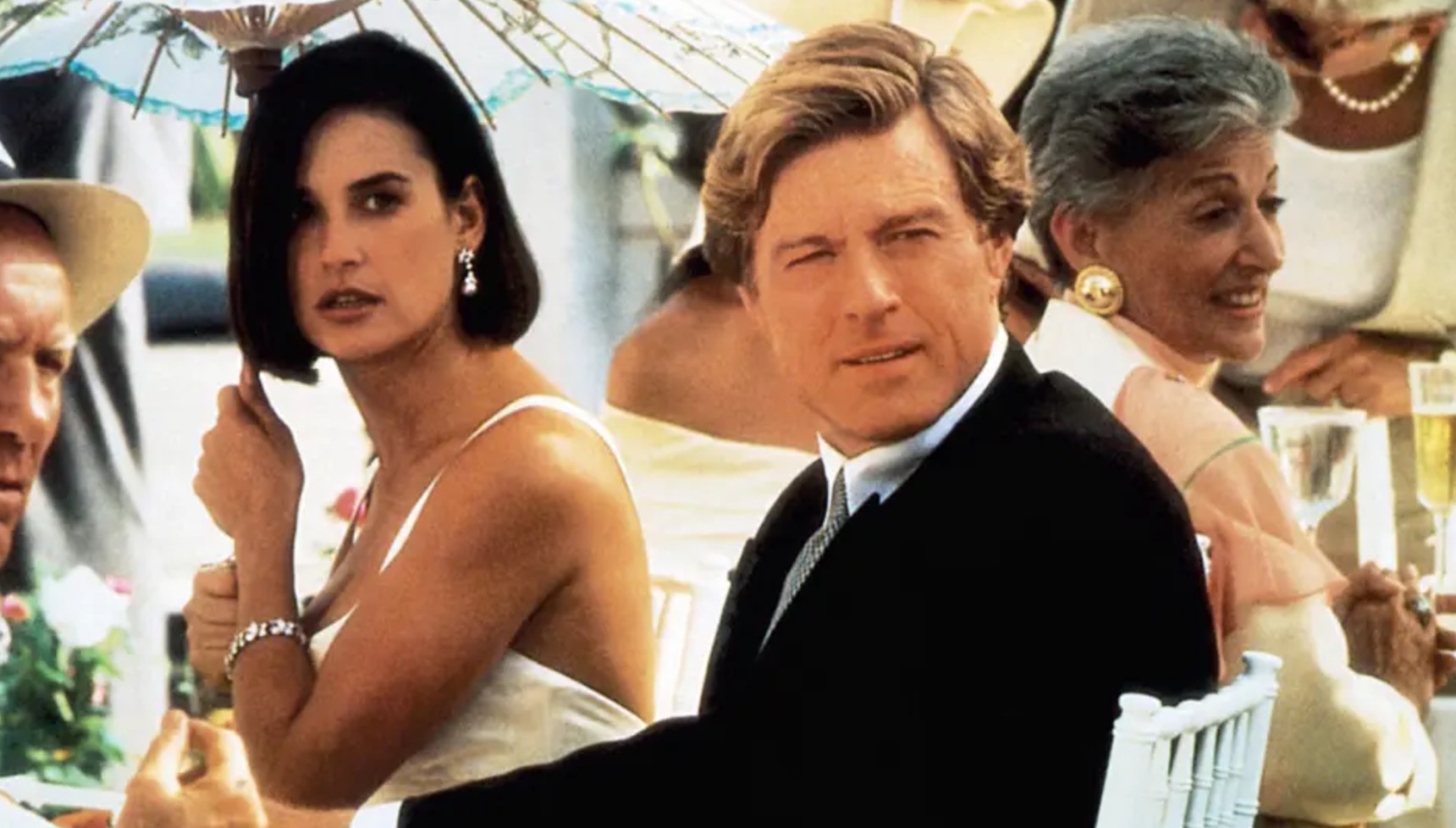 Demi Moore sitting at a table with Robert Redford in Indecent Proposal