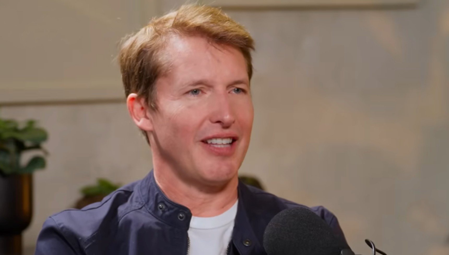 James Blunt wearing a blue shirt and white t-shirt 