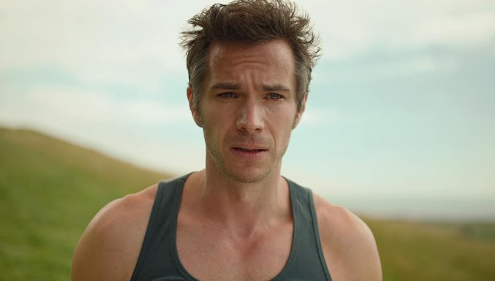 James D'Arcy wearing a sweaty vest in a field in Broadchurch