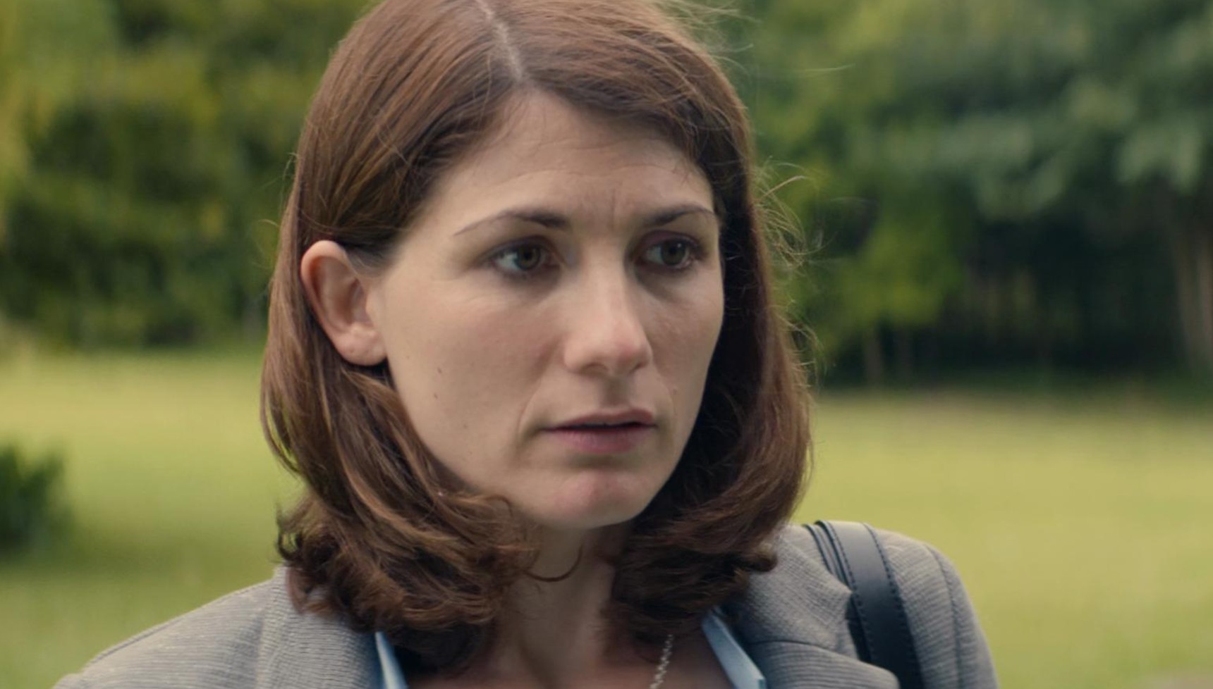 Jodie Whittaker standing in a green field in Broadchurch
