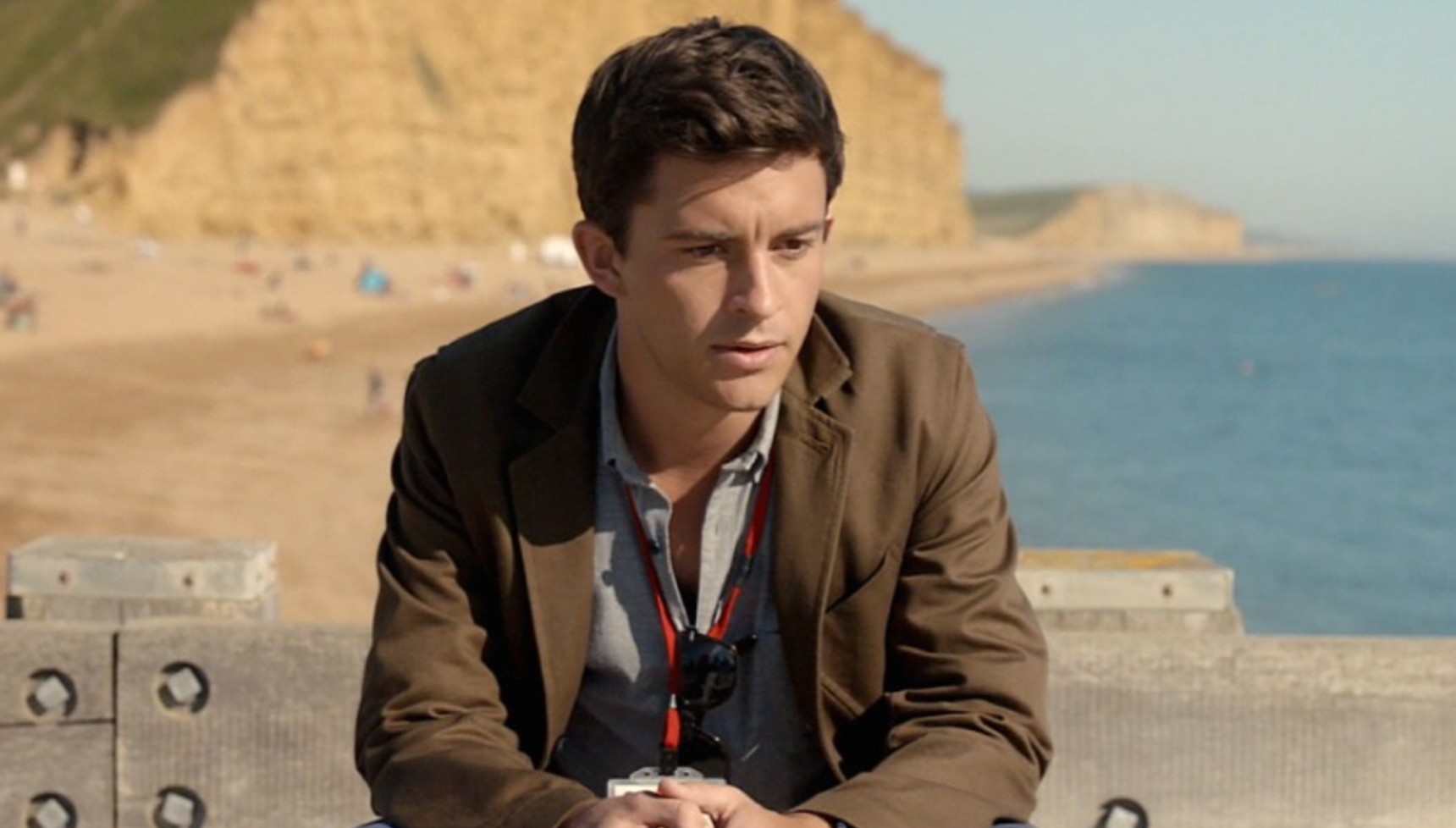 Jonathan Bailey sitting near a beach in Broadchurch