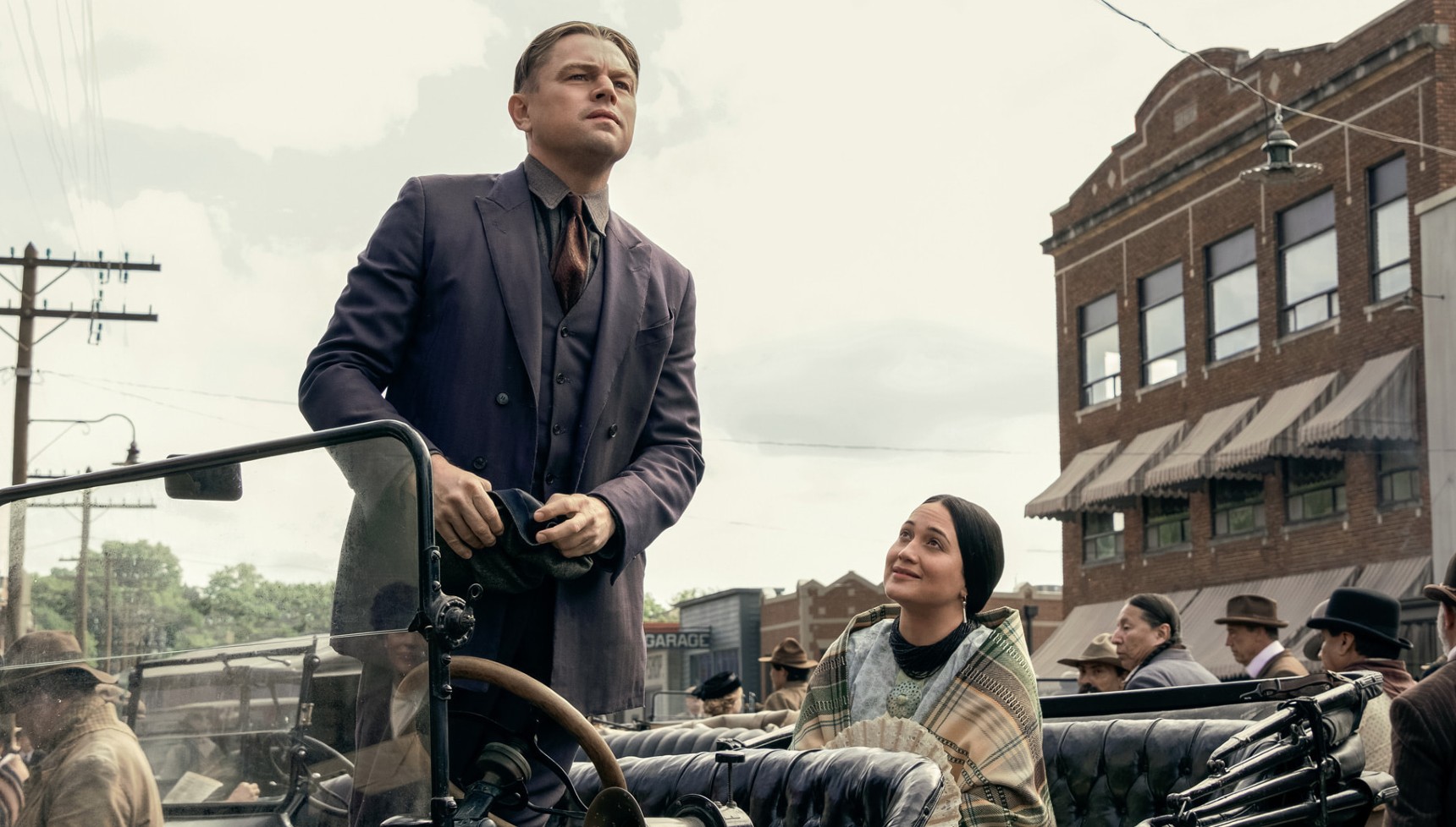 A man stands up in his roofless vehicle as a woman watches on