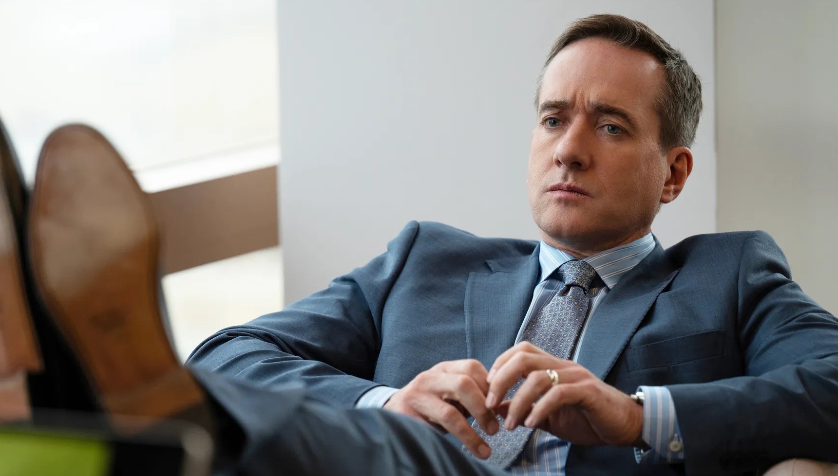 Matthew Macfadyen with his feet on the table in Succession